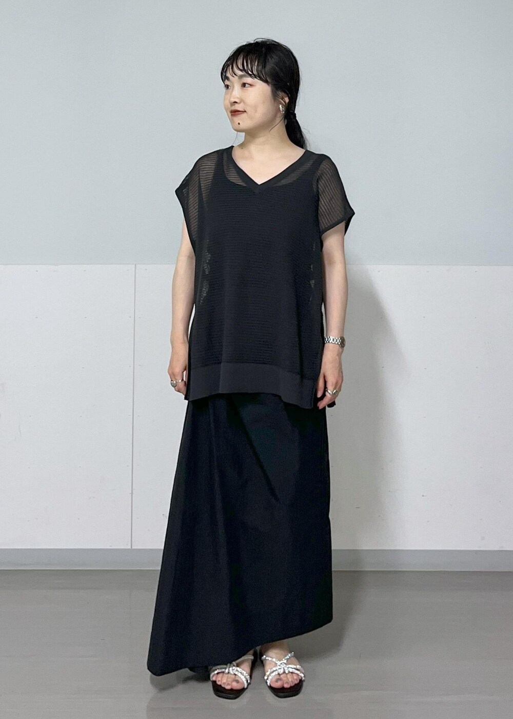 シルバー系のサンダル、ホワイト系のショルダーバッグ、ブラック系のタンクトップを着用したレディースの春コーディネートの7枚目の写真