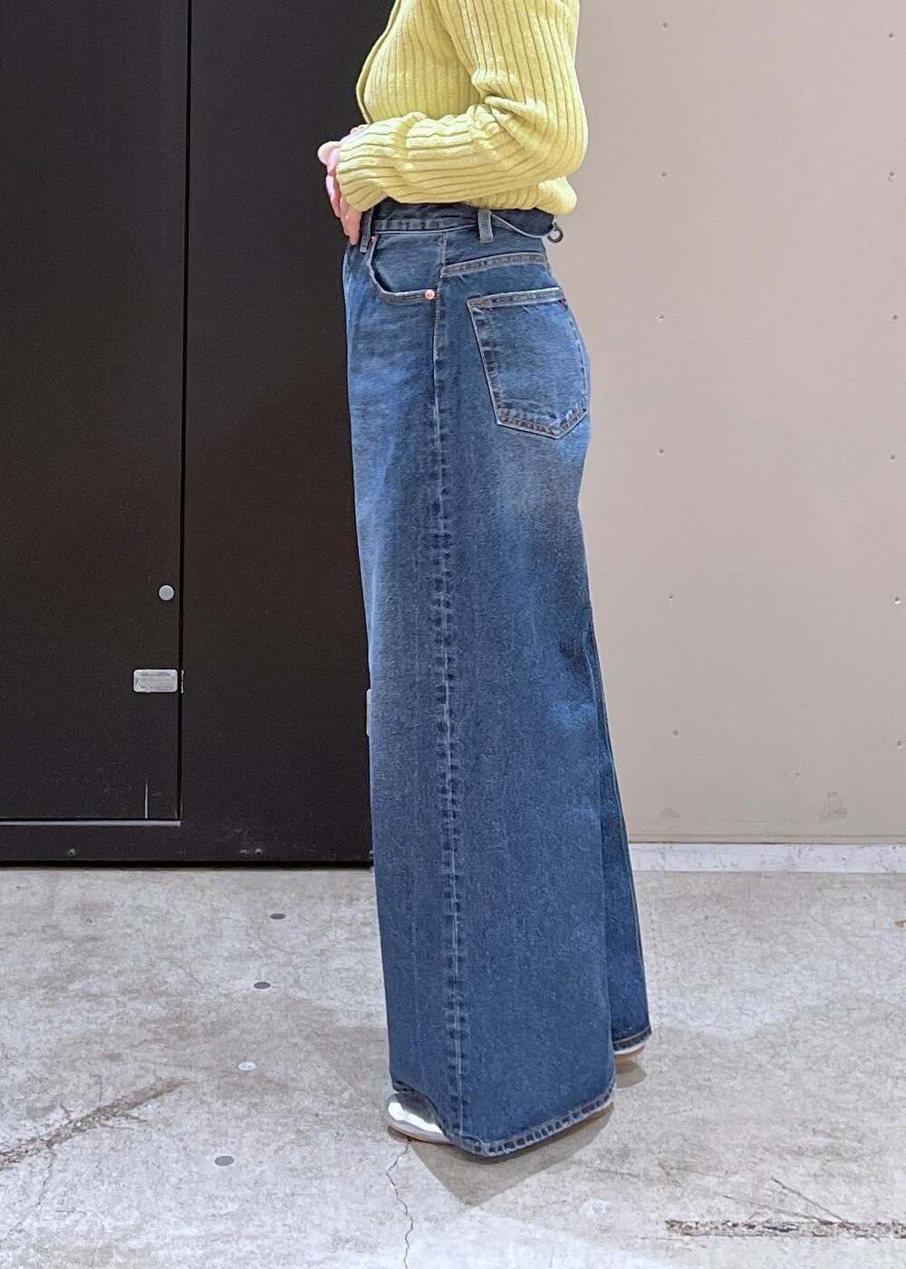 イエロー系のニット/セーター、ブルー系のデニムパンツ、ブラック系のその他アウターを着用したレディースの冬コーディネートの8枚目の写真