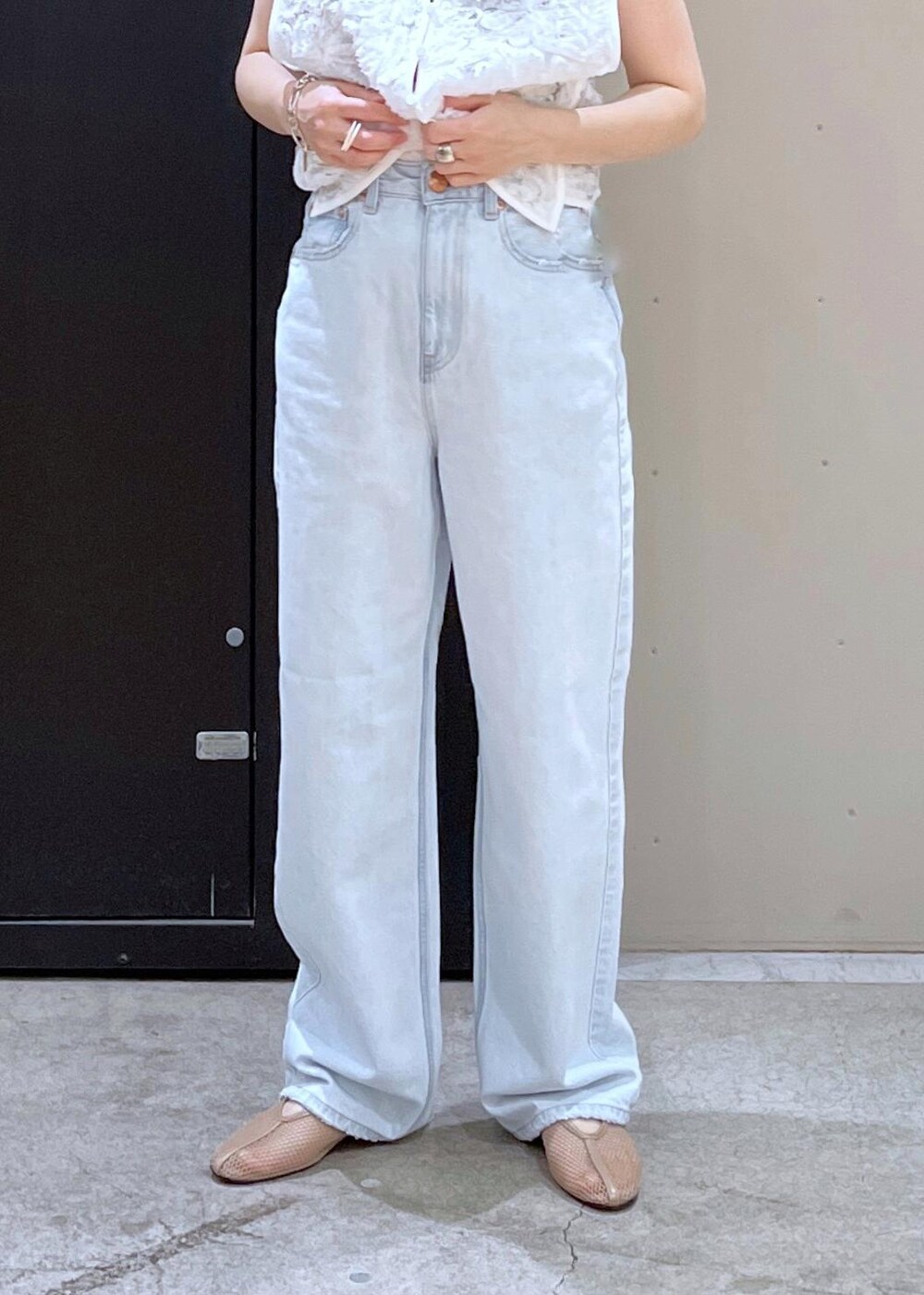 ベージュ系のボストンバッグ、ベージュ系のパンプス、ブルー系のデニムパンツを着用したレディースの冬コーディネートの6枚目の写真