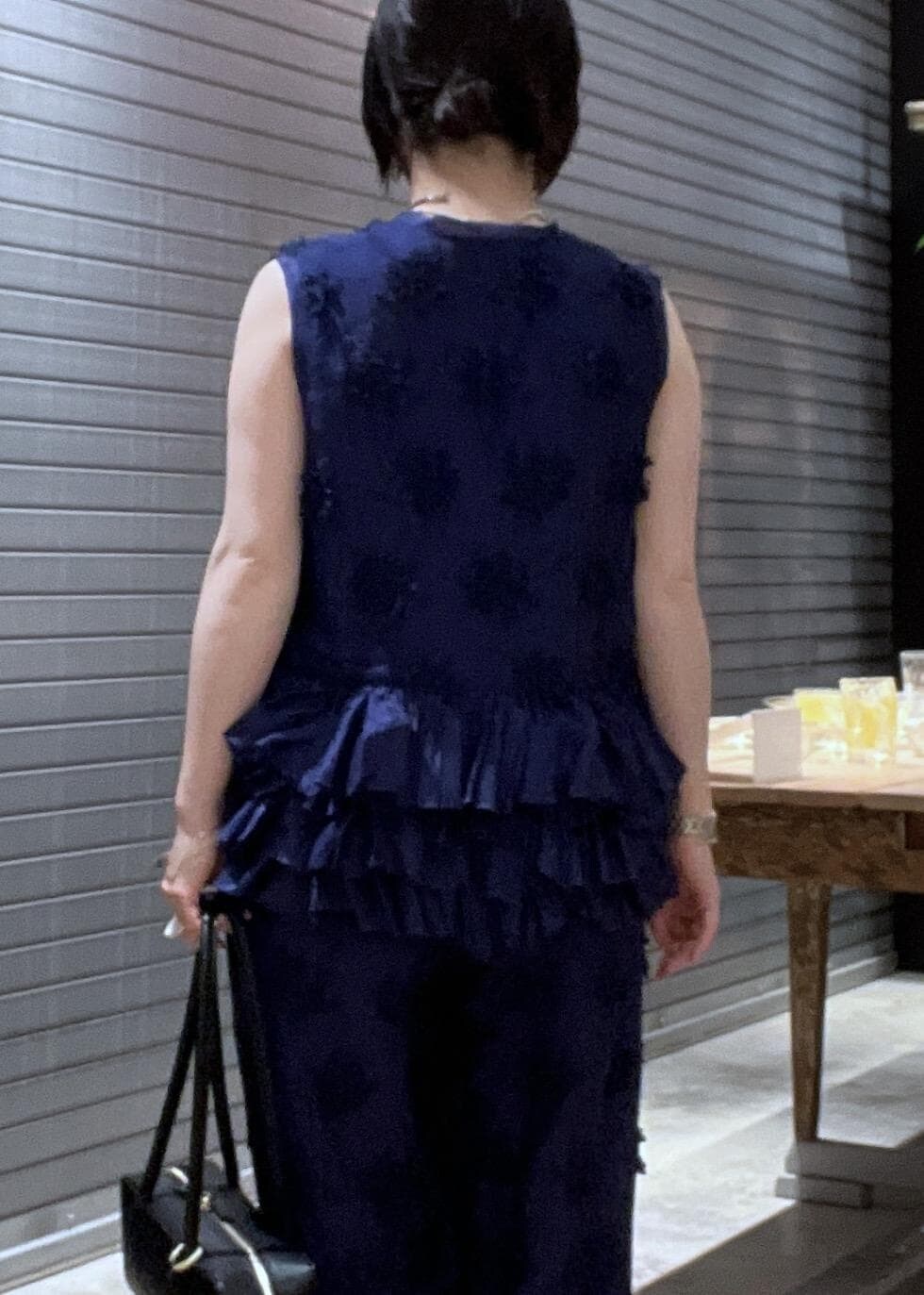 ブルー系のシャツ/ブラウス、ブラック系のサンダル、ブルー系のベストを着用したレディースの春コーディネートの6枚目の写真