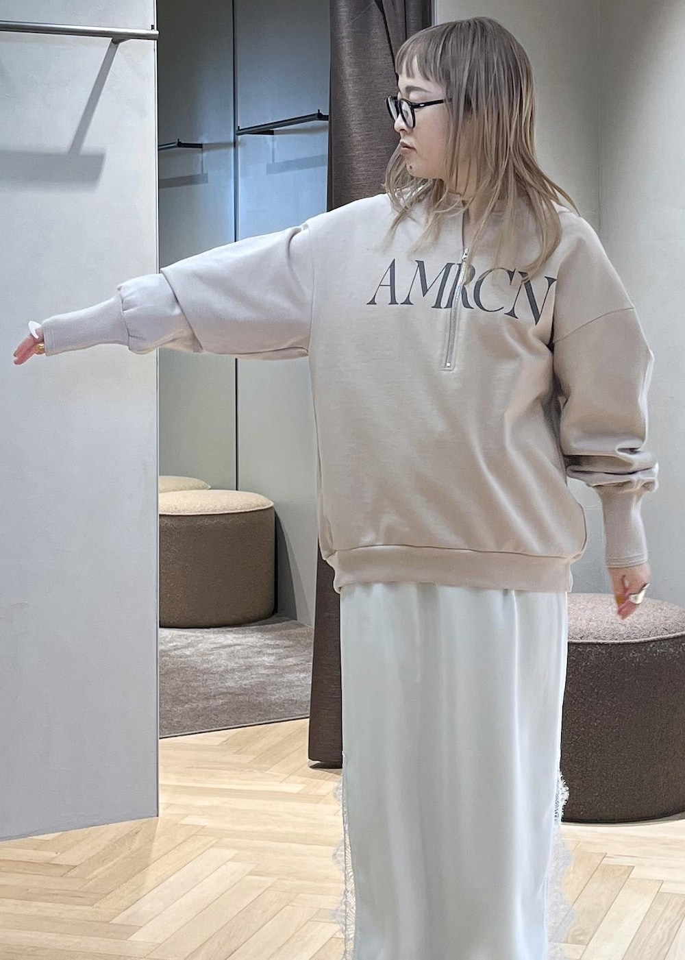 ベージュ系のスウェット、ブルー系のデニムパンツ、ホワイト系のスカートを着用したレディースの冬コーディネートの7枚目の写真