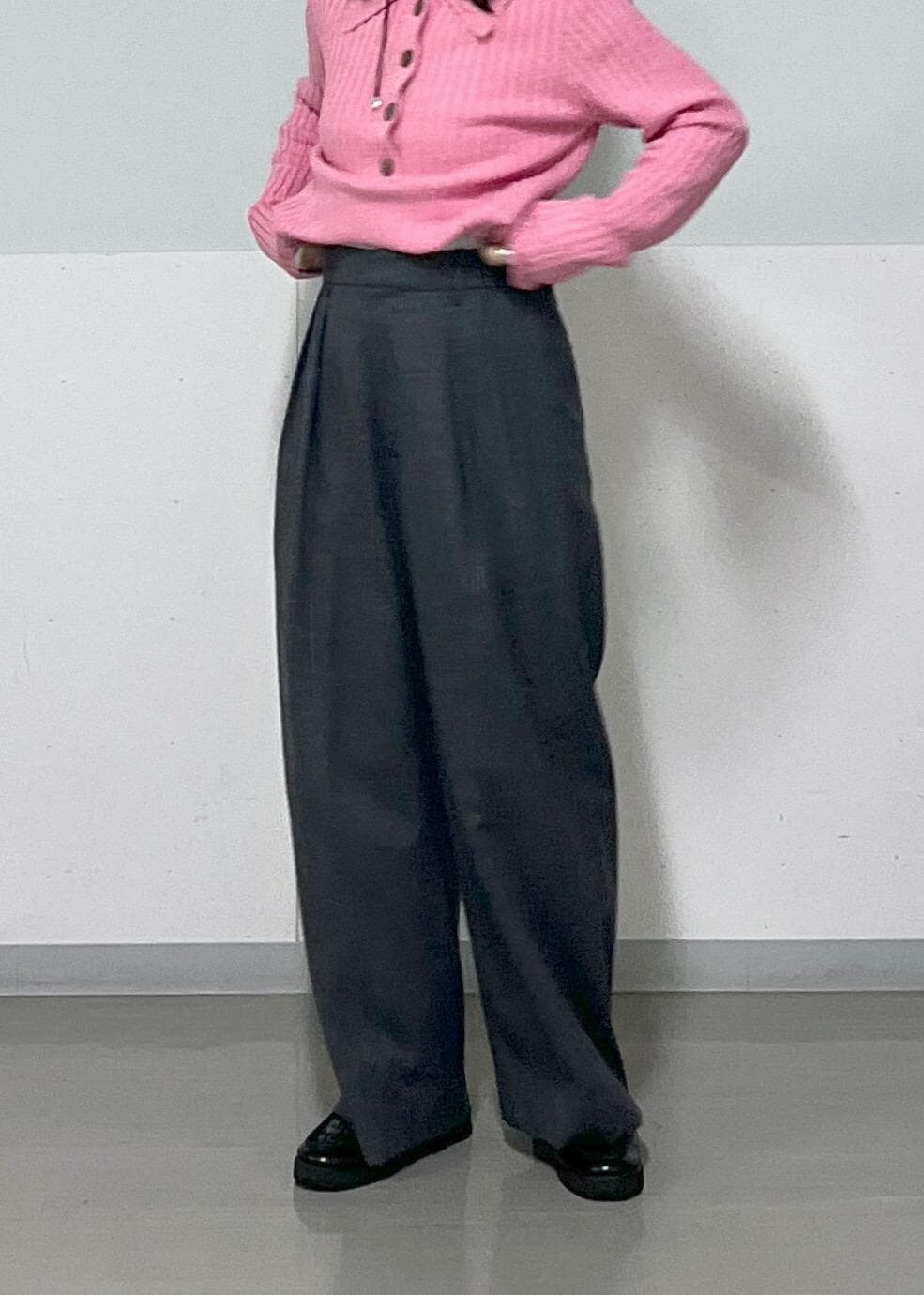 グレー系のスラックス、ブラック系のトートバッグ、ピンク系のニット/セーターを着用したレディースの冬コーディネートの6枚目の写真