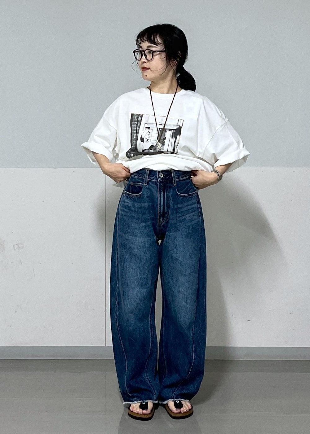 ブラック系のトートバッグ、ブルー系のデニムパンツ、ホワイト系のTシャツ/カットソーを着用したレディースの夏コーディネートの6枚目の写真