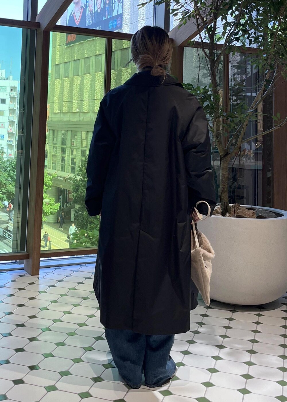 ベージュ系のショルダーバッグ、ブラック系のダウンジャケット/コート、ブルー系のデニムジャケットを着用したレディースの秋コーディネートの3枚目の写真