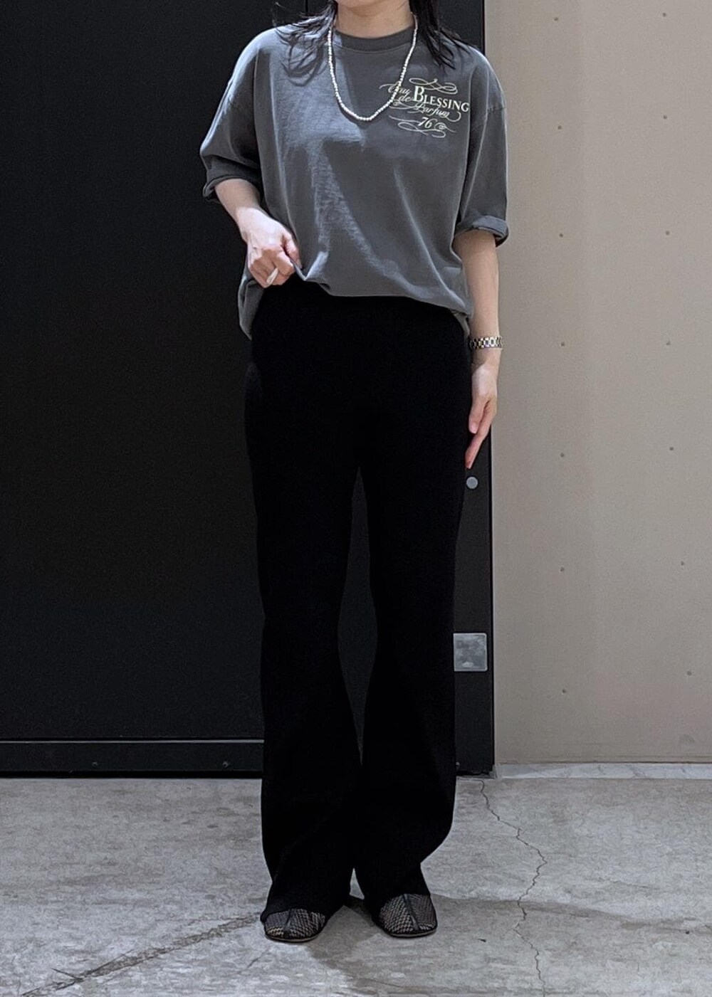 ブラック系のショルダーバッグ、ブラック系のその他パンツ、ベージュ系のTシャツ/カットソーを着用したレディースの春コーディネートの4枚目の写真