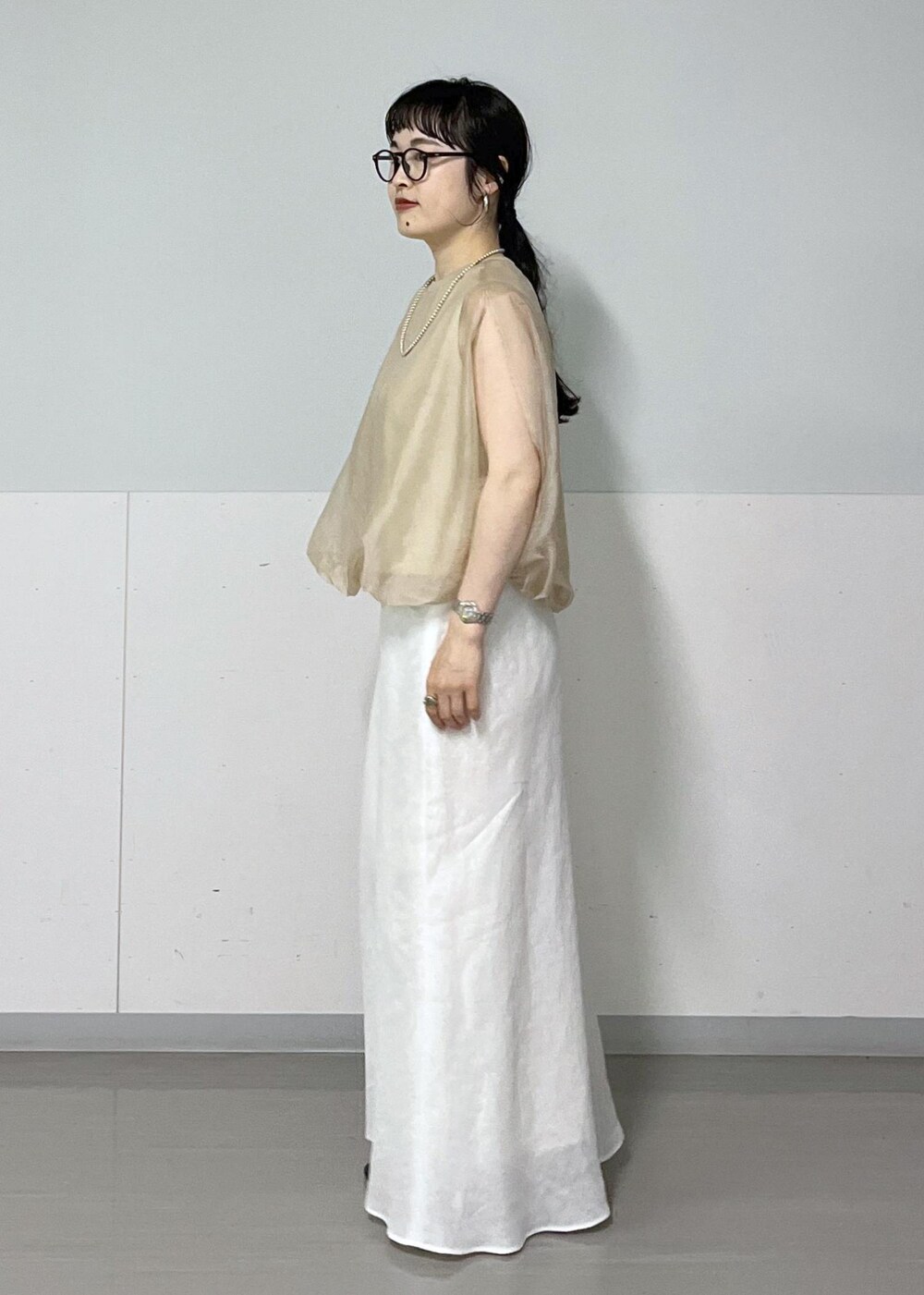 ブラック系のサンダル、ホワイト系のスカート、ベージュ系のTシャツ/カットソーを着用したレディースの春コーディネートの2枚目の写真