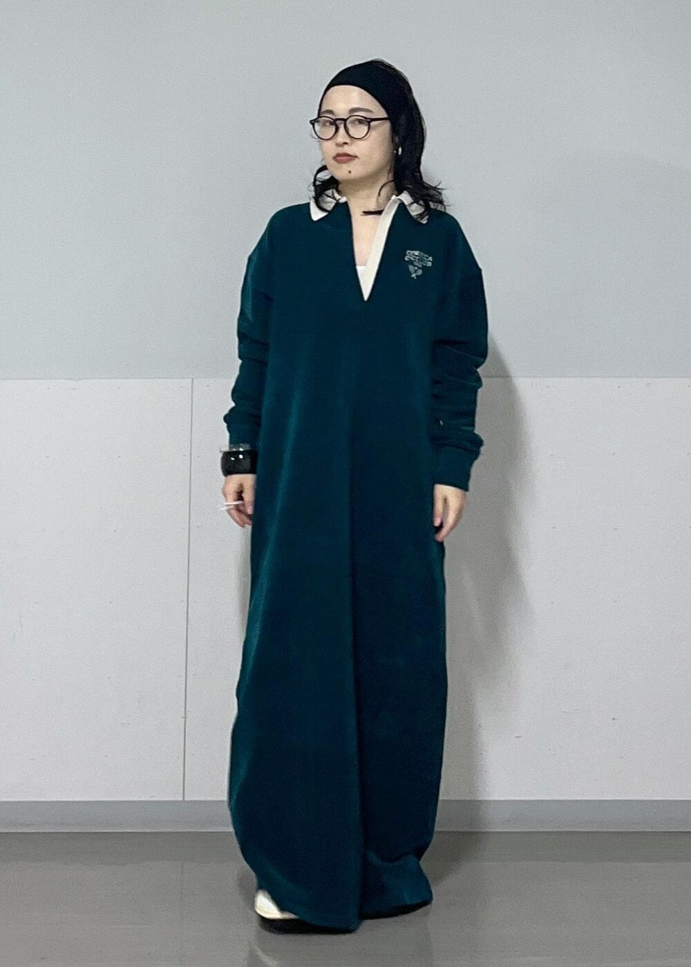 ホワイト系のハンドバッグ、ホワイト系のカーディガン/ボレロ、グリーン系のワンピースを着用したレディースの冬コーディネートの3枚目の写真