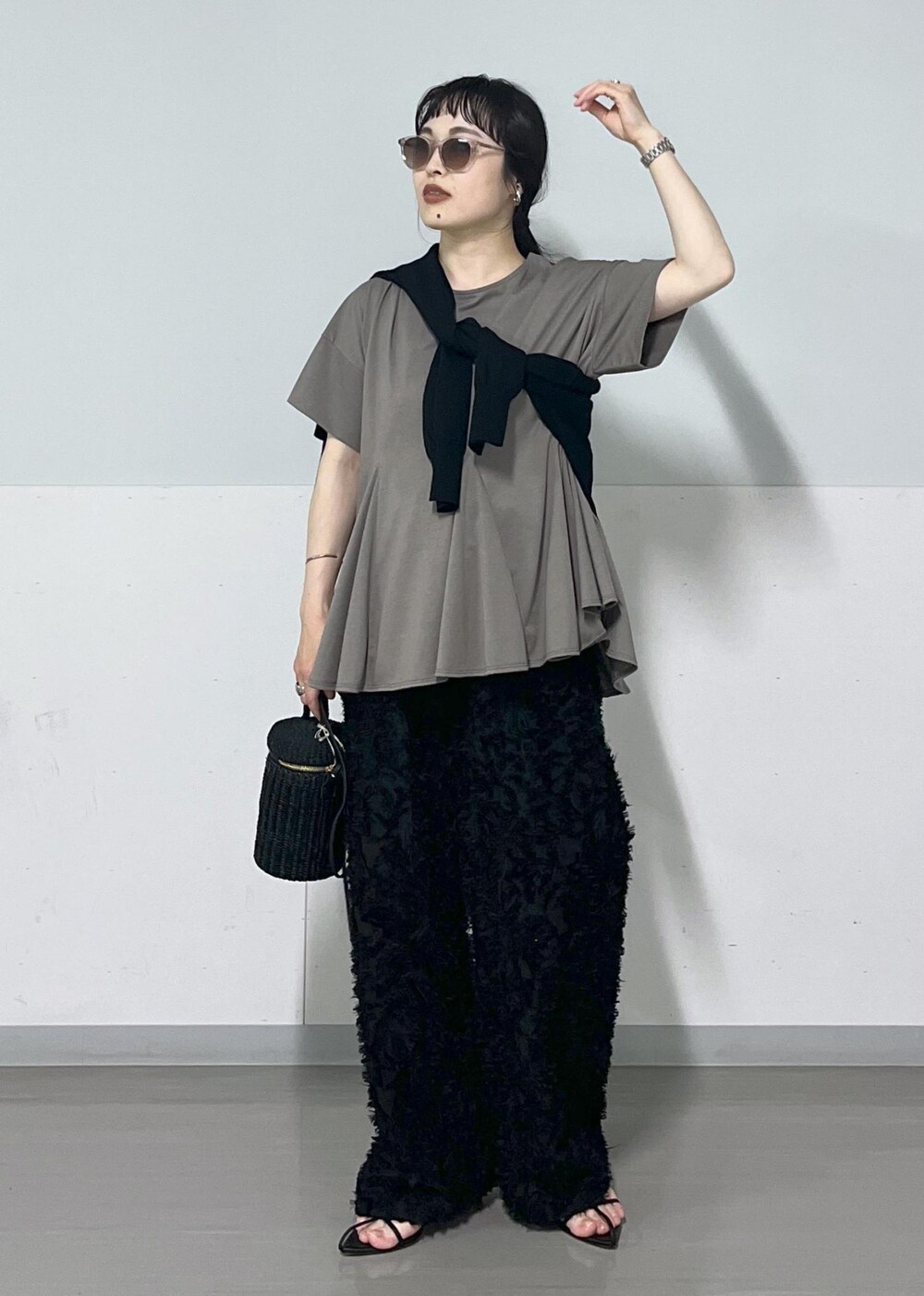 ブラック系のサンダル、ブラック系のショルダーバッグ、ブラック系のカーディガン/ボレロを着用したレディースの春コーディネートの2枚目の写真