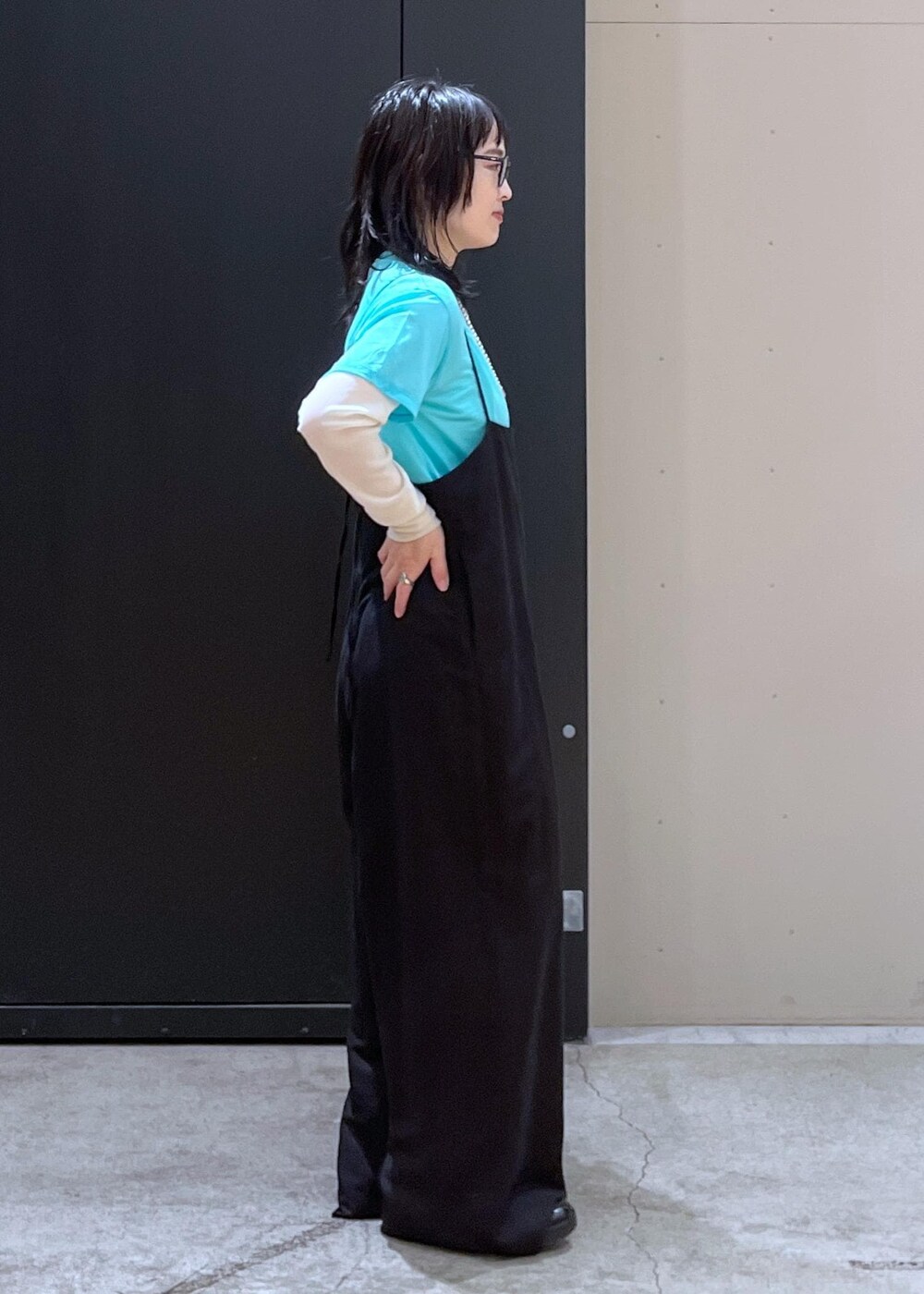 グリーン系のショルダーバッグ、ブラック系のサロペット/オーバーオール、ブルー系のTシャツ/カットソーを着用したレディースの冬コーディネートの3枚目の写真