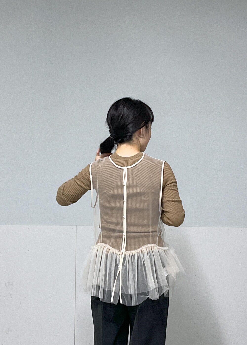 ブラック系のその他パンツ、ブラック系のブーツ、ホワイト系のベストを着用したレディースの秋コーディネートの5枚目の写真