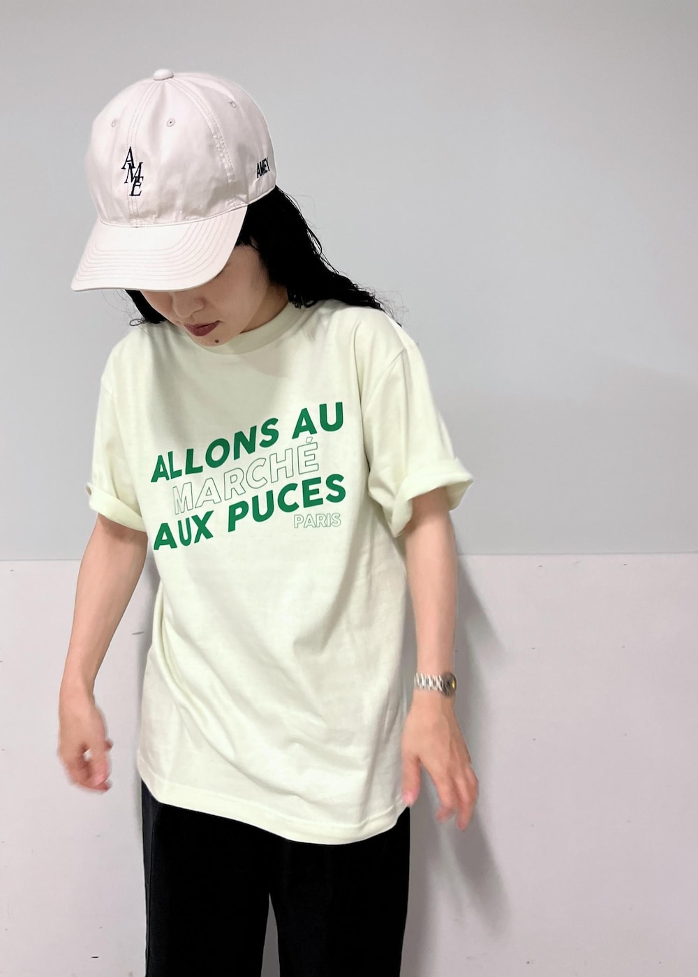 ブラック系のデニムパンツ、グリーン系のTシャツ/カットソー、ブラック系のサンダルを着用したレディースの夏コーディネートの5枚目の写真