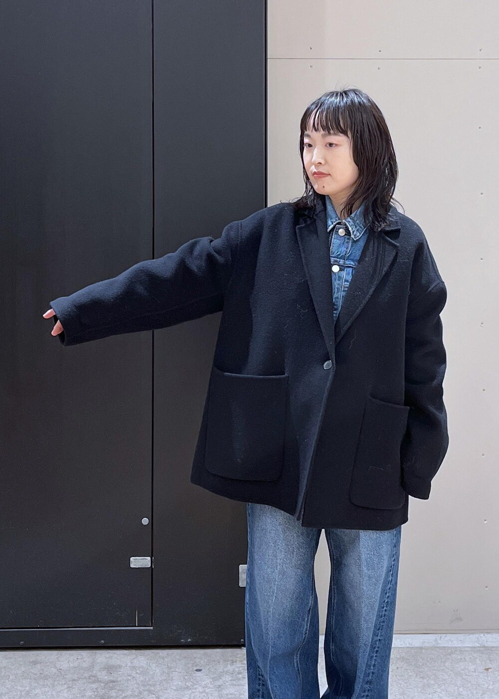 イエロー系のニット/セーター、ブルー系のデニムパンツ、ブラック系のその他アウターを着用したレディースの冬コーディネートの4枚目の写真