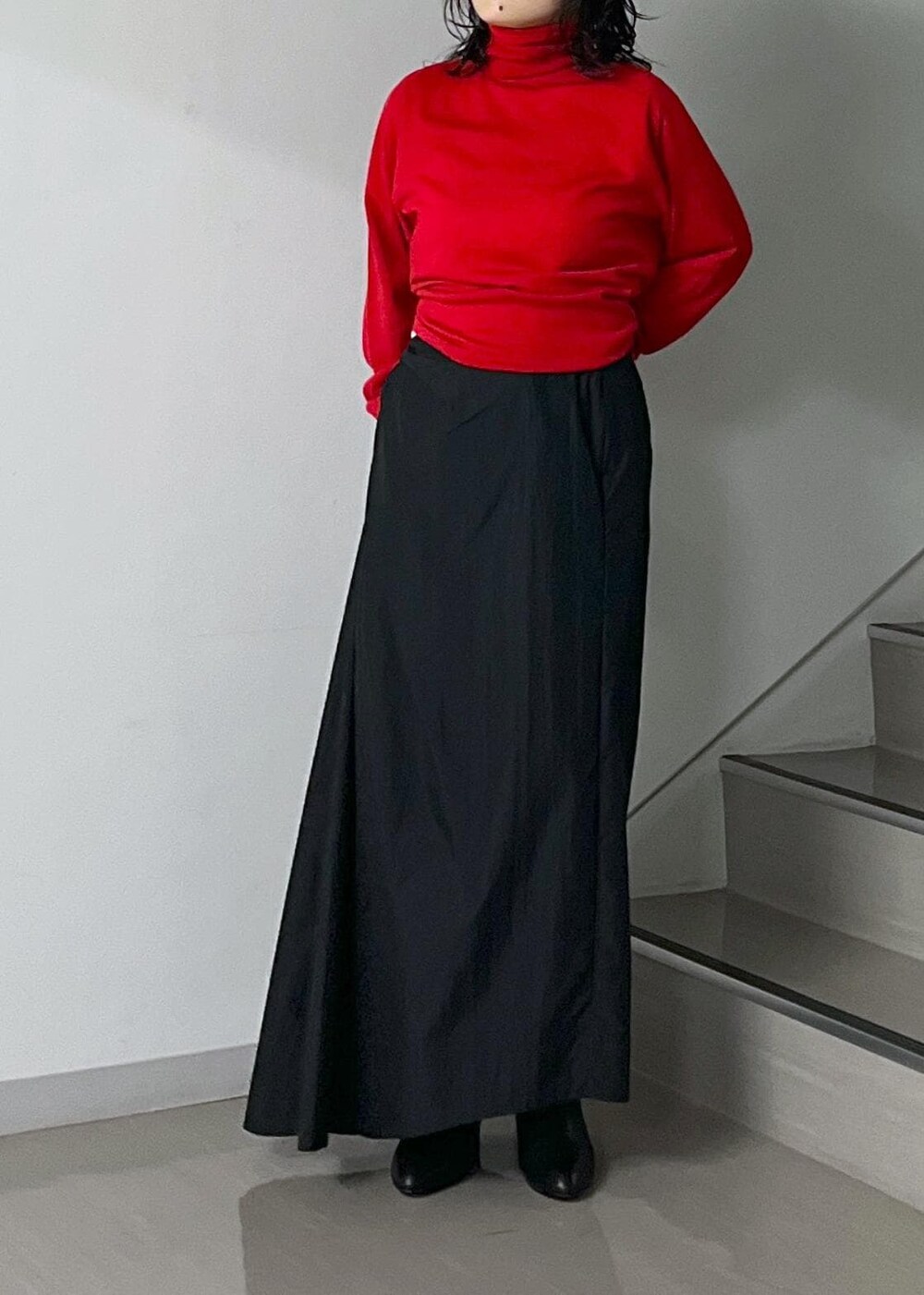 ブラック系のスカート、レッド系のニット/セーター、グレー系のスカートを着用したレディースの秋コーディネートの6枚目の写真