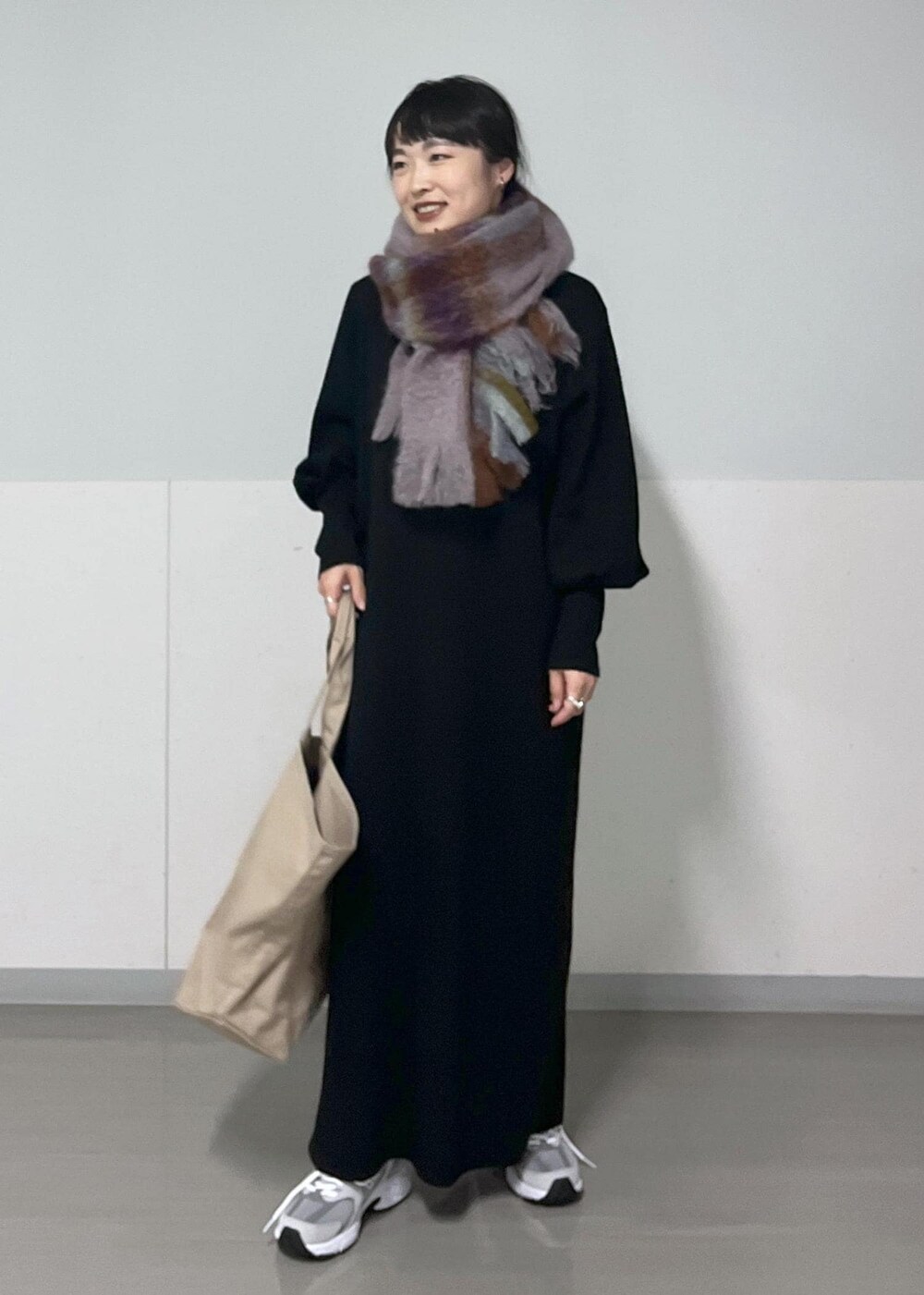 ホワイト系のTシャツ/カットソー、ブラック系のワンピース、グレー系のスニーカーを着用したレディースの秋コーディネートの2枚目の写真