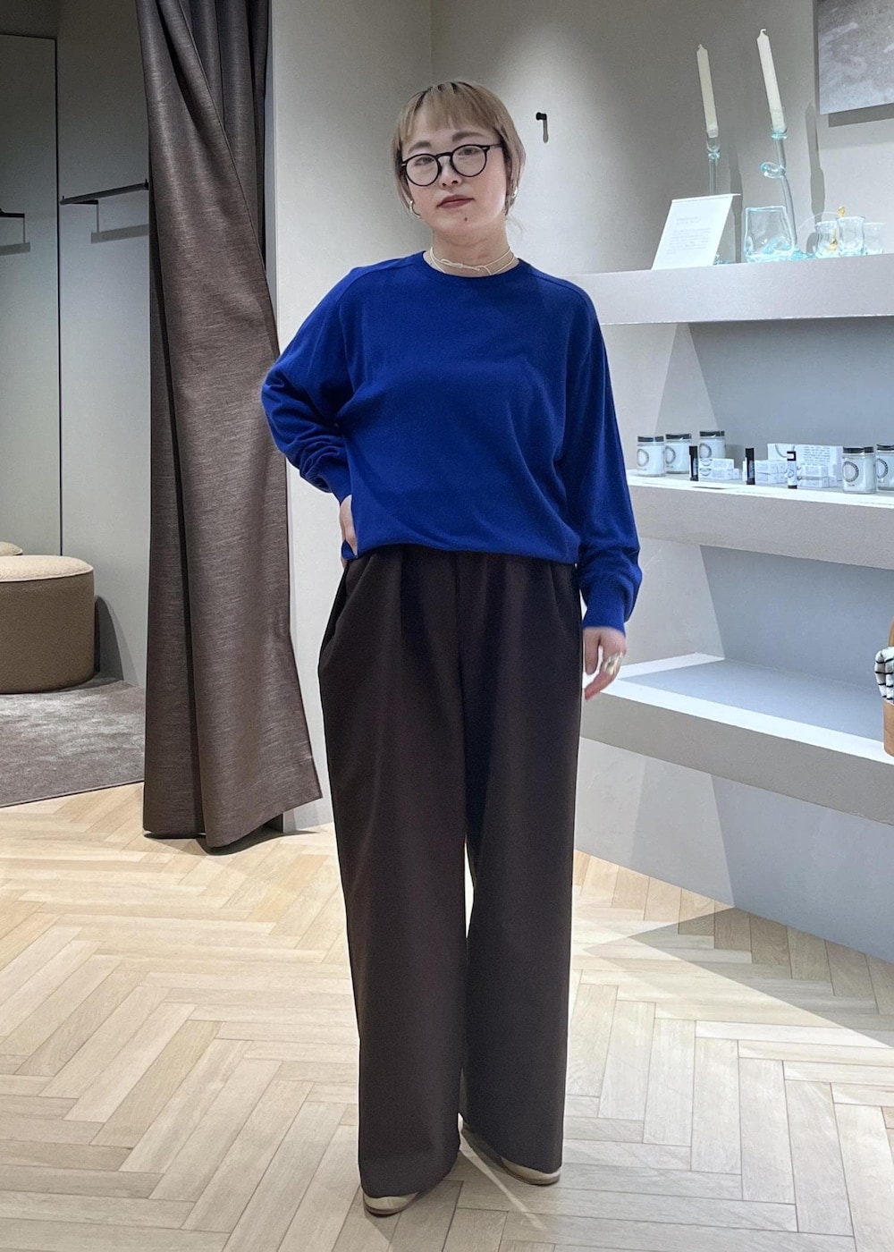 ブラック系のショルダーバッグ、ブラウン系のその他パンツ、ブルー系のニット/セーターを着用したレディースの春コーディネートの5枚目の写真