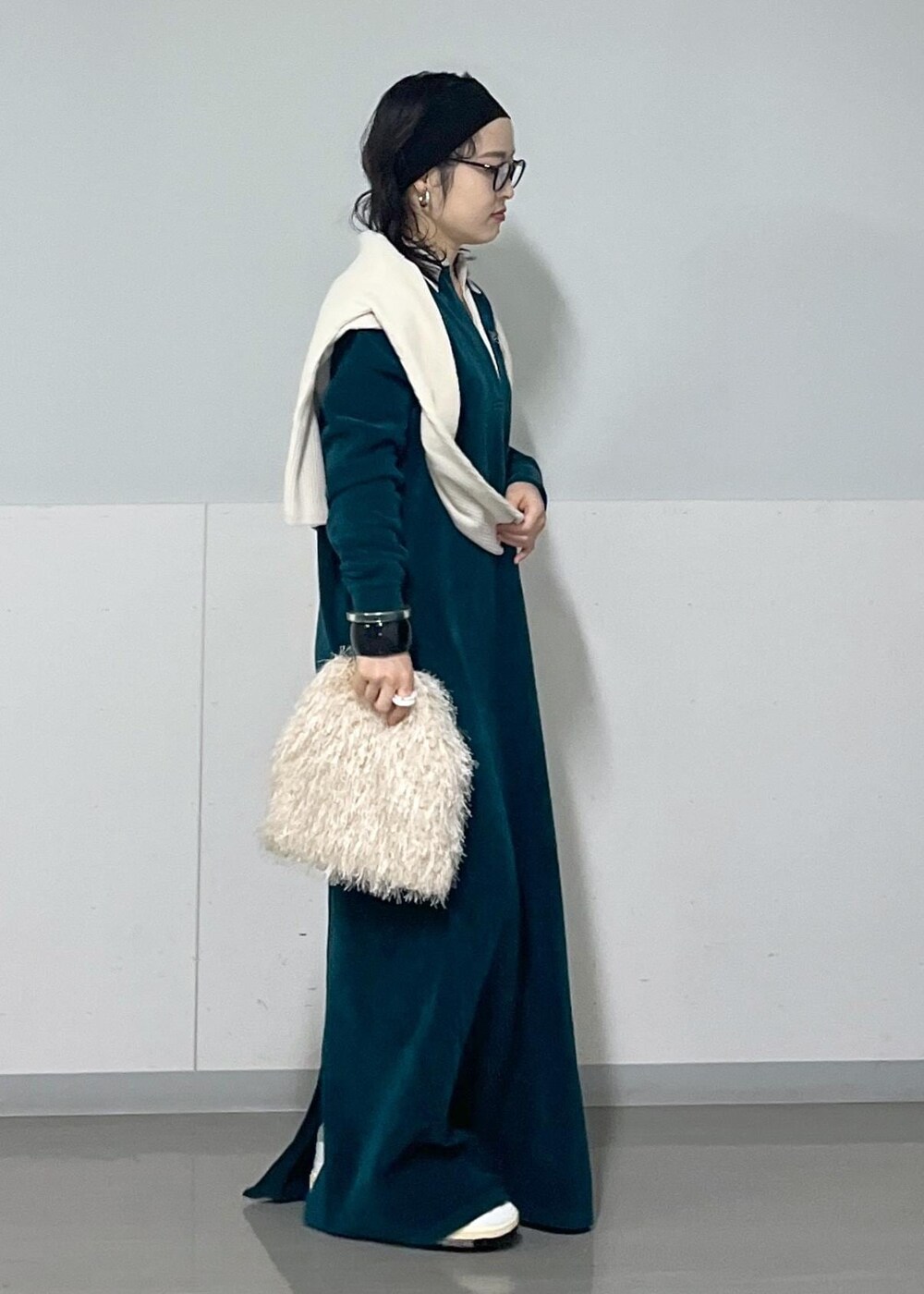 ホワイト系のハンドバッグ、ホワイト系のカーディガン/ボレロ、グリーン系のワンピースを着用したレディースの冬コーディネートの2枚目の写真