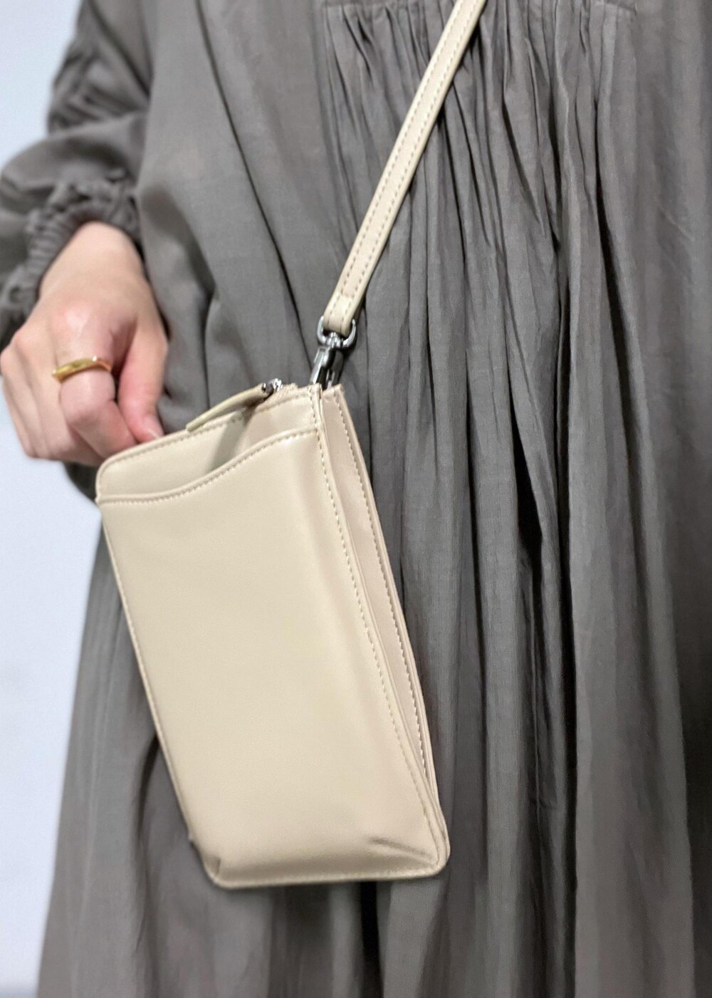 ブラウン系のサンダル、ベージュ系のショルダーバッグ、グレー系のワンピースを着用したレディースの夏コーディネートの7枚目の写真