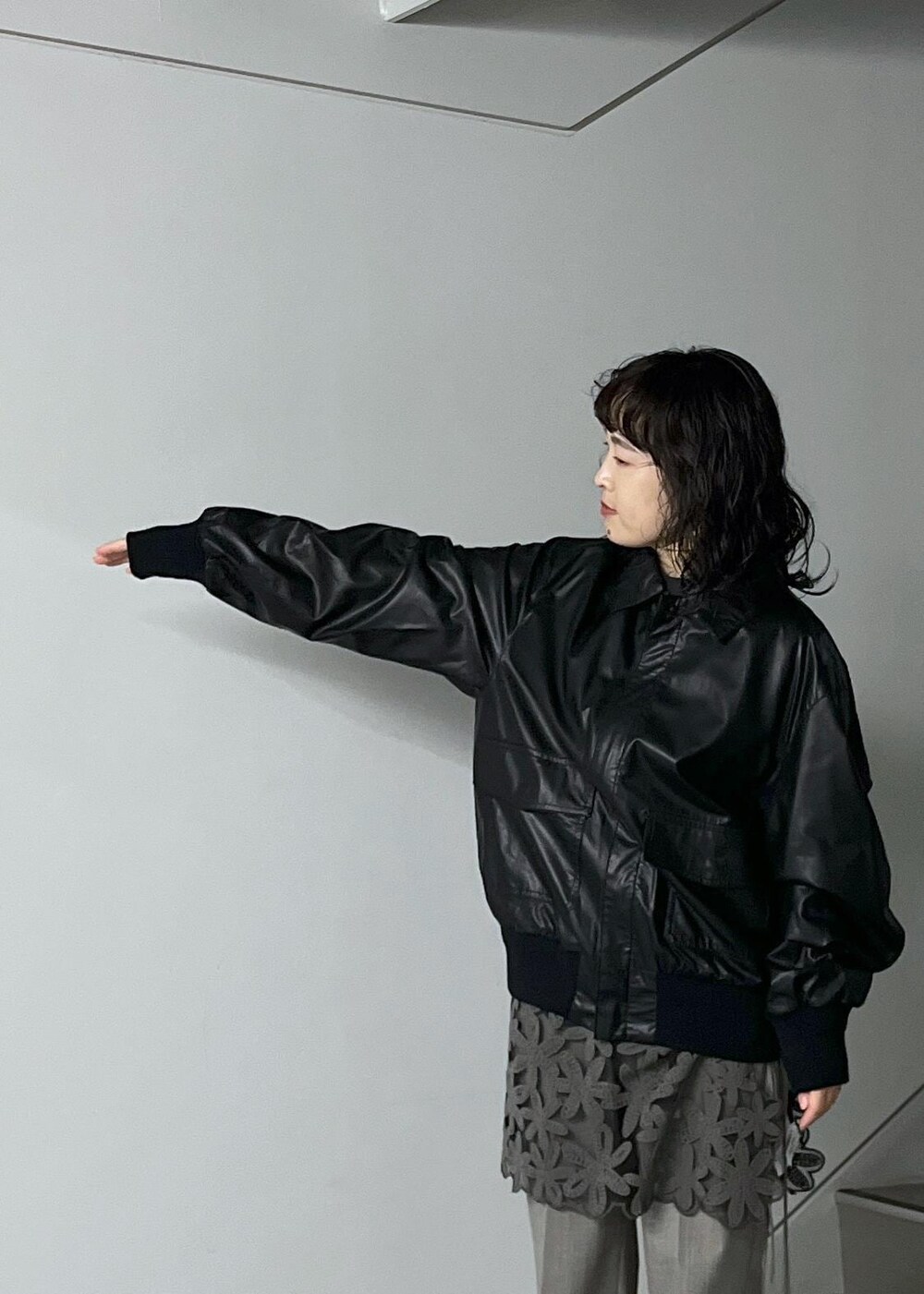 ブルー系のトートバッグ、グレー系のスラックス、ブラック系のTシャツ/カットソーを着用したレディースの秋コーディネートの5枚目の写真