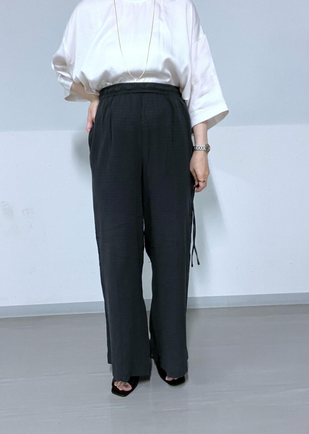 ホワイト系のTシャツ/カットソー、ブラック系のサンダル、ブラック系のその他パンツを着用したレディースの夏コーディネートの7枚目の写真