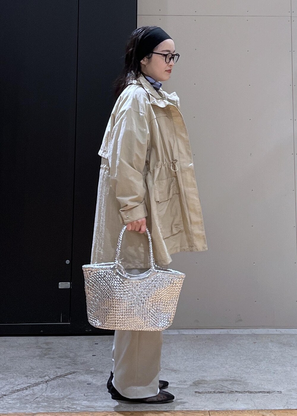 グレー系のスラックス、ベージュ系のブルゾン、ブラック系のパンプスを着用したレディースの春コーディネートの5枚目の写真