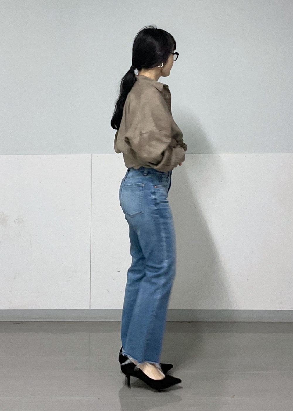 グリーン系のシャツ/ブラウス、ブラック系のショルダーバッグ、ブルー系のデニムパンツを着用したレディースの春コーディネートの2枚目の写真