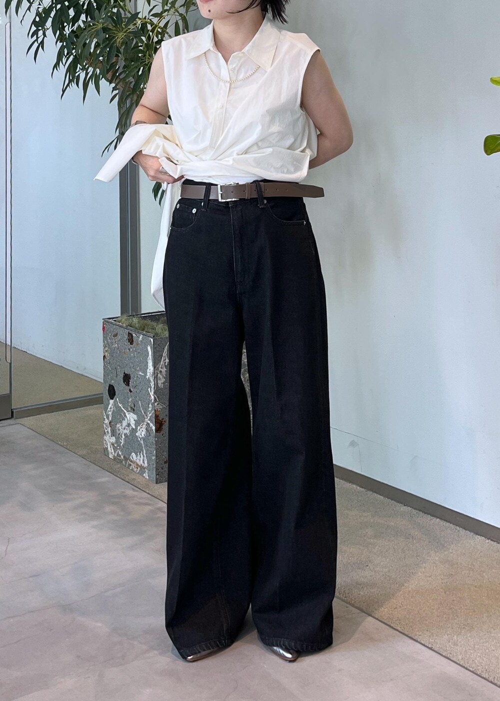 グレー系のデニムパンツ、ホワイト系のシャツ/ブラウス、ブラウン系のショルダーバッグを着用したレディースの夏コーディネートの4枚目の写真