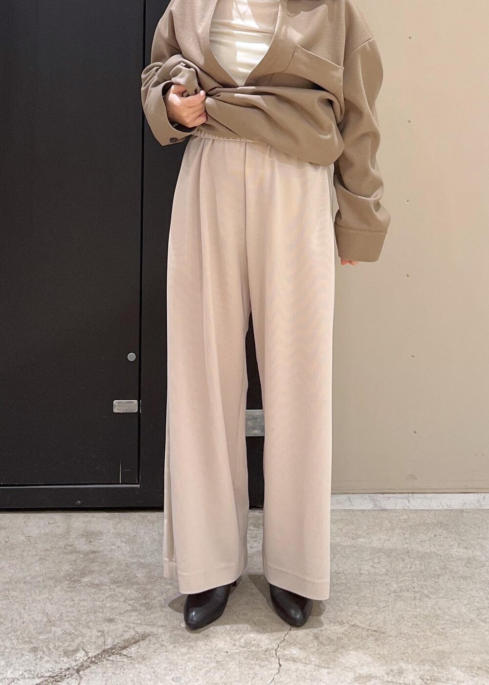 ブラック系のブーツ、イエロー系のワンピース、グレー系のブルゾンを着用したレディースの冬コーディネートの6枚目の写真