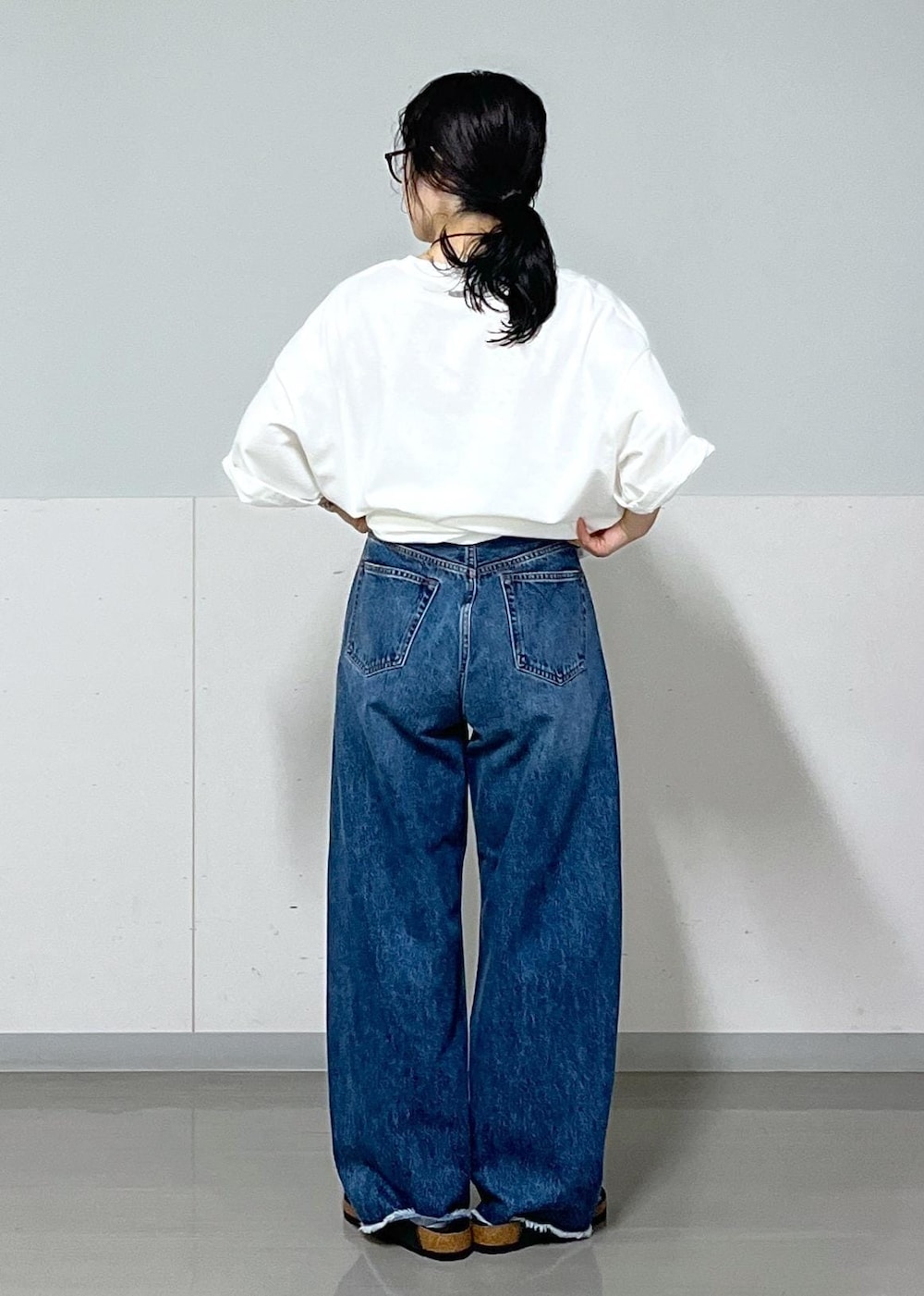 ブラック系のトートバッグ、ブルー系のデニムパンツ、ホワイト系のTシャツ/カットソーを着用したレディースの夏コーディネートの7枚目の写真