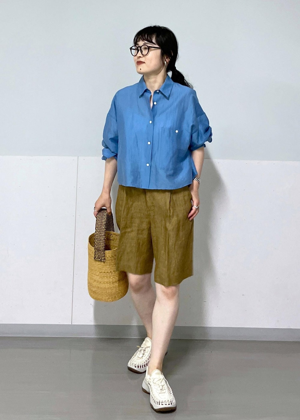 ホワイト系のサンダル、ベージュ系のかごバッグ、ブルー系のシャツ/ブラウスを着用したレディースの春コーディネートの2枚目の写真