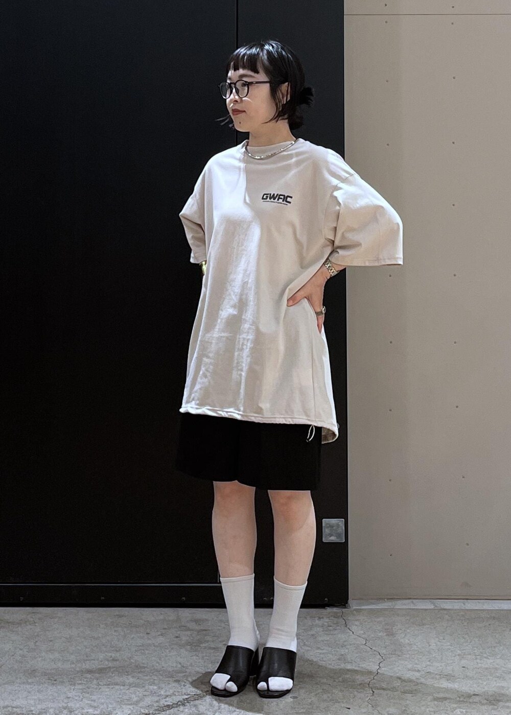 ブラック系のサンダル、ホワイト系のTシャツ/カットソー、ベージュ系のベストを着用したレディースの夏コーディネートの7枚目の写真