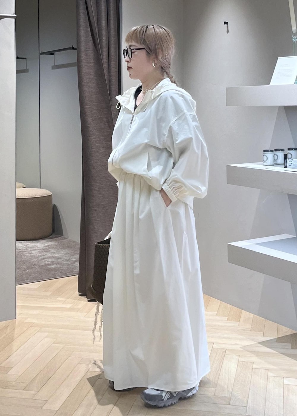 ホワイト系のブルゾン、ホワイト系のスカート、イエロー系のトートバッグを着用したレディースの春コーディネートの2枚目の写真