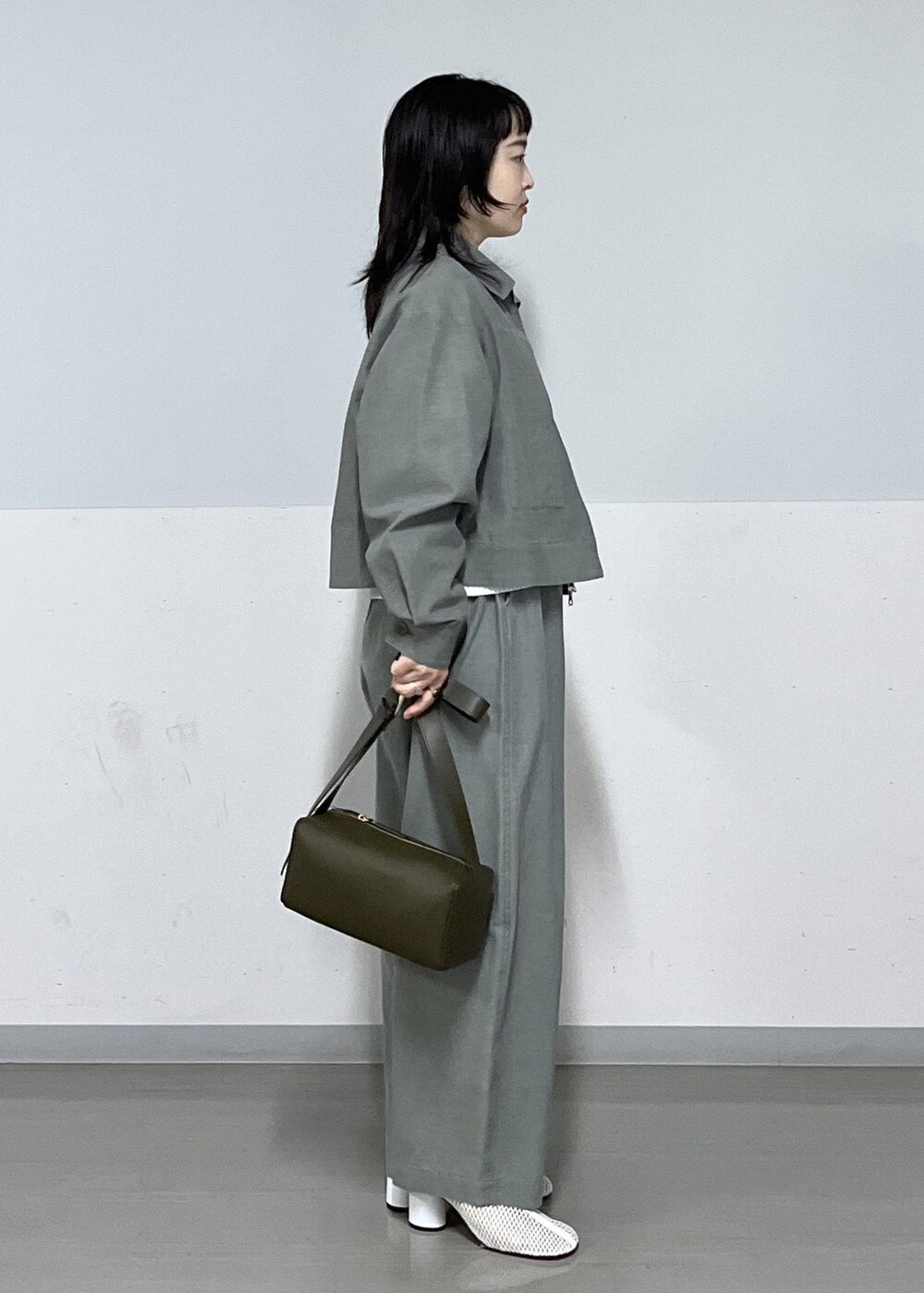 ブラック系のショルダーバッグ、グリーン系のブルゾン、グリーン系のその他パンツを着用したレディースの春コーディネートの2枚目の写真