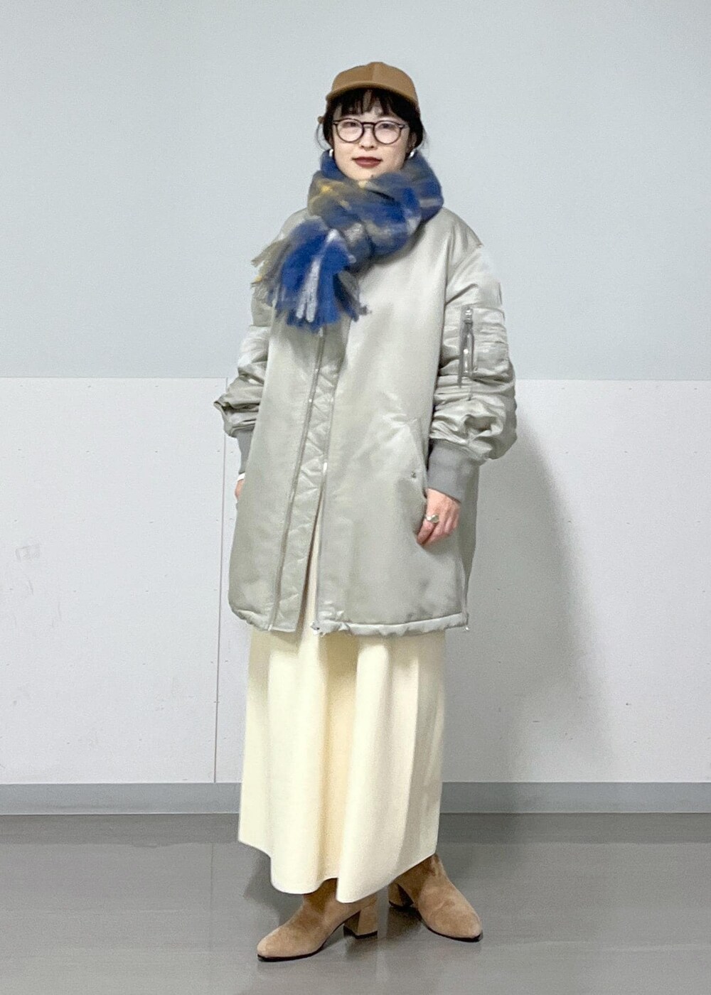 ブラウン系のブーツ、グレー系のMA-1、ホワイト系のワンピースを着用したレディースの冬コーディネートの2枚目の写真