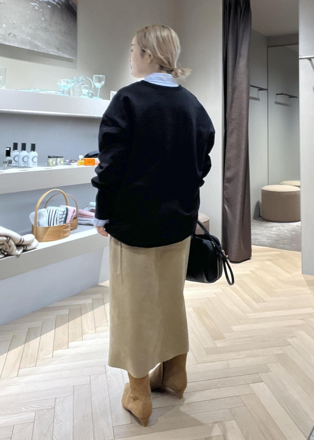 ベージュ系のスカート、ブラック系のショルダーバッグ、イエロー系のブーツを着用したレディースの冬コーディネートの3枚目の写真