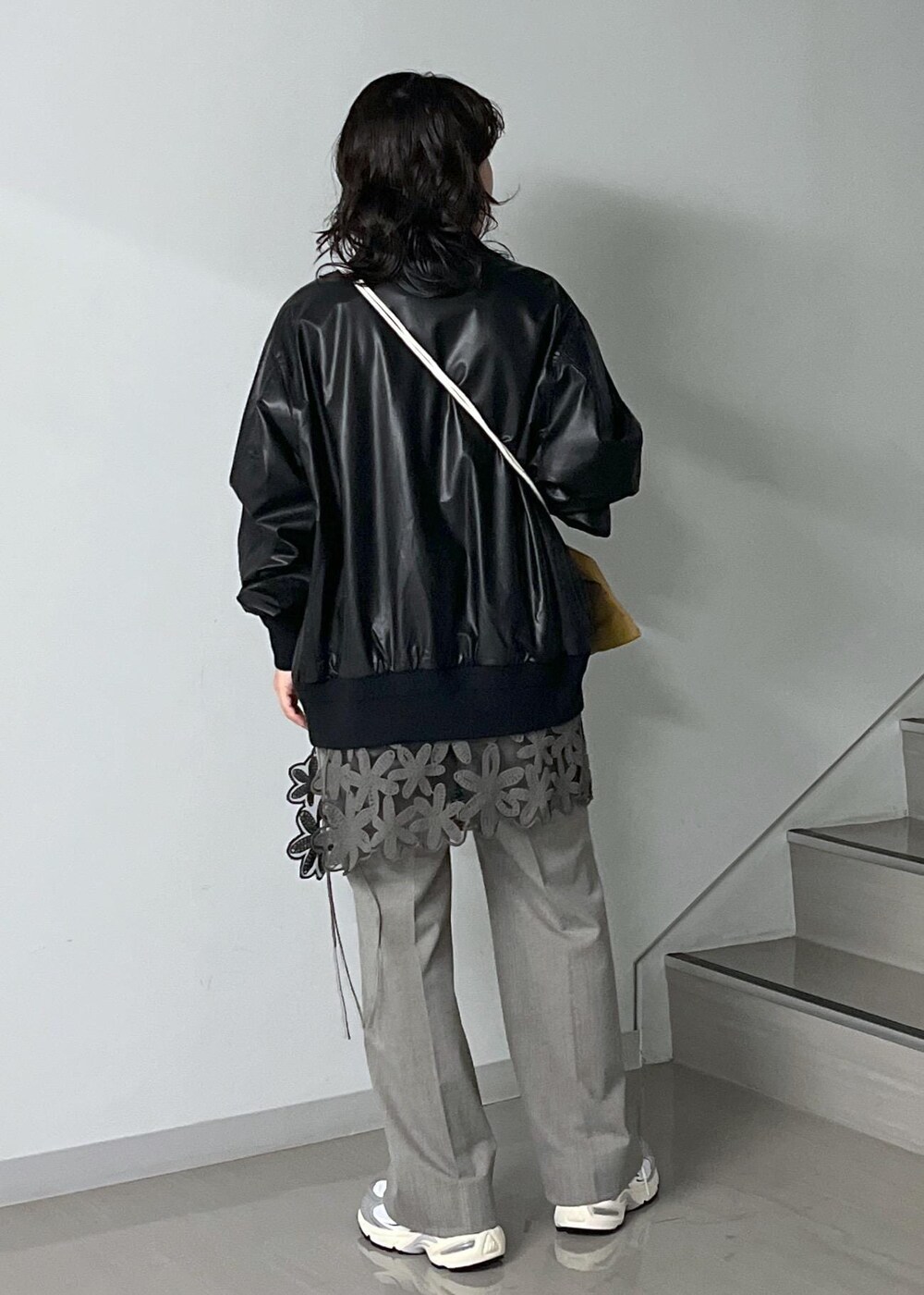 ブルー系のトートバッグ、グレー系のスラックス、ブラック系のTシャツ/カットソーを着用したレディースの秋コーディネートの4枚目の写真