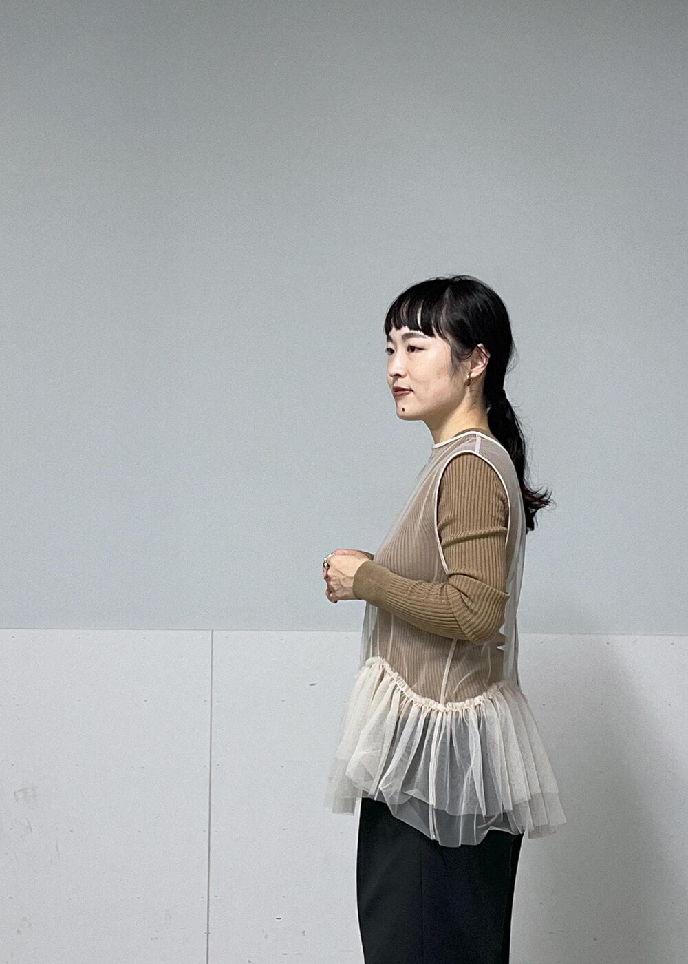 ブラック系のその他パンツ、ブラック系のブーツ、ホワイト系のベストを着用したレディースの秋コーディネートの4枚目の写真