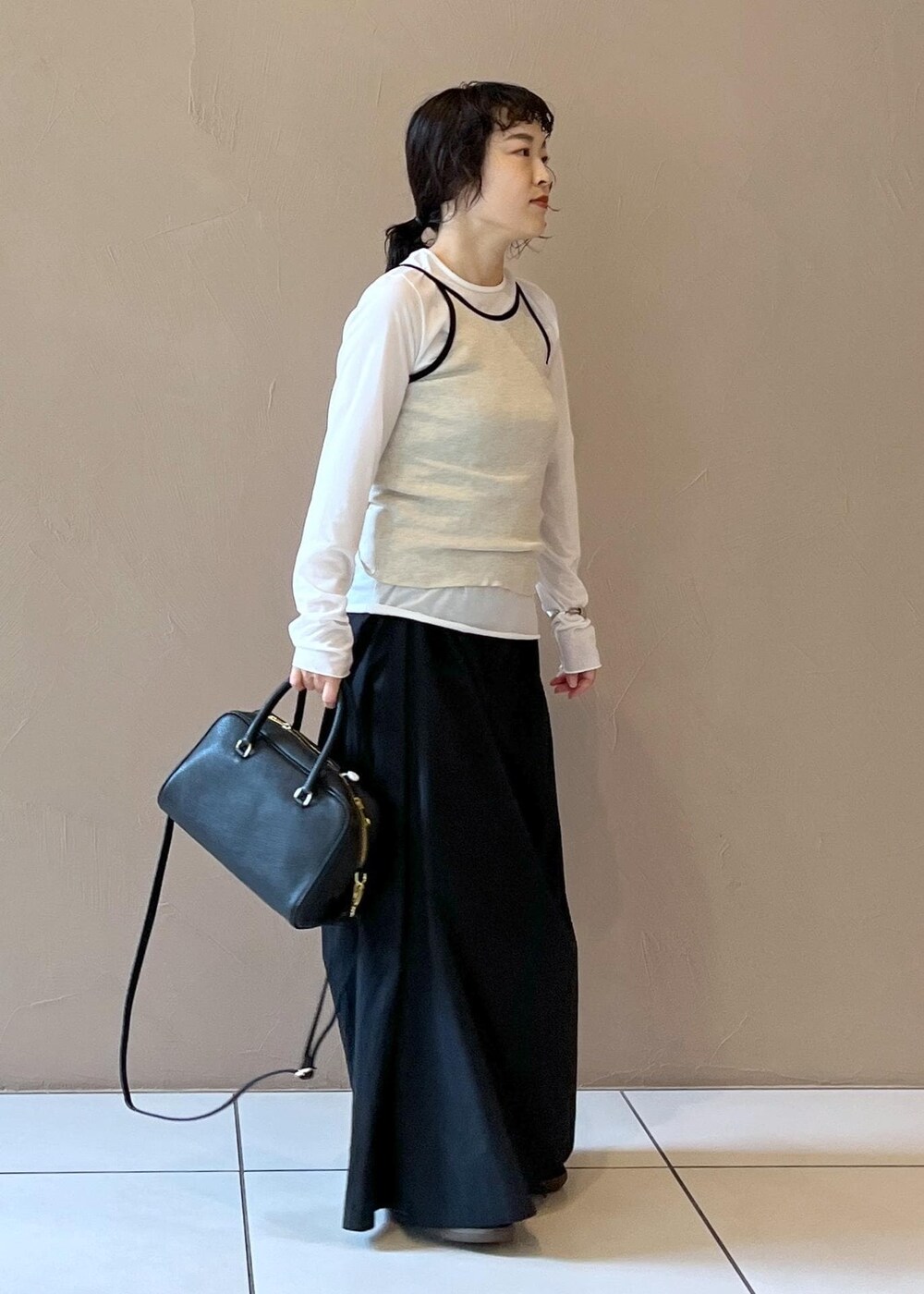 ブラック系のスカート、ベージュ系のタンクトップ、ホワイト系のTシャツ/カットソーを着用したレディースの夏コーディネートの4枚目の写真