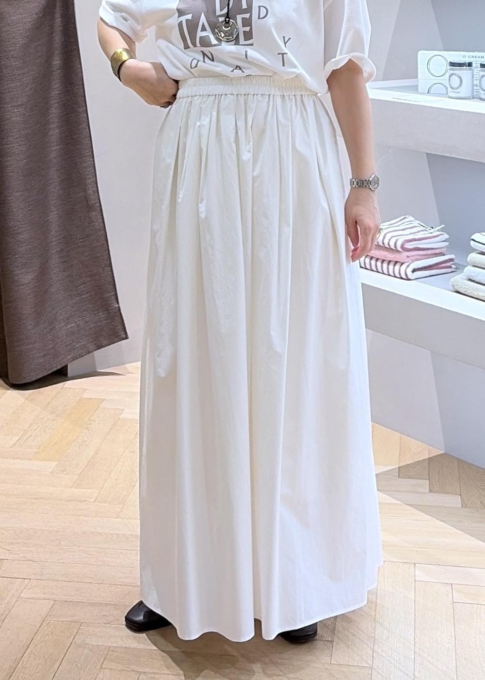 ホワイト系のスカート、ホワイト系のベスト、ホワイト系のTシャツ/カットソーを着用したレディースの夏コーディネートの4枚目の写真