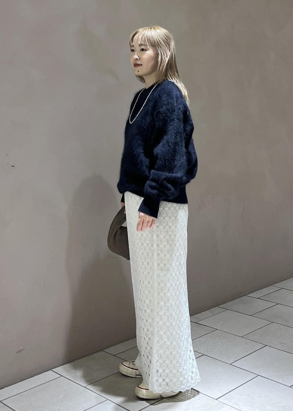ホワイト系のスカート、ブルー系のニット/セーター、ホワイト系のスラックスを着用したレディースの秋コーディネートの4枚目の写真