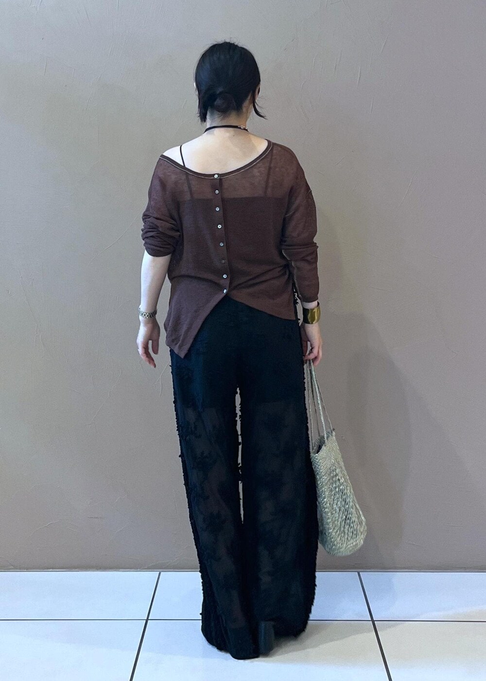 ブラック系のチューブトップ、ブラック系のサンダル、ブラウン系のカーディガン/ボレロを着用したレディースの夏コーディネートの3枚目の写真