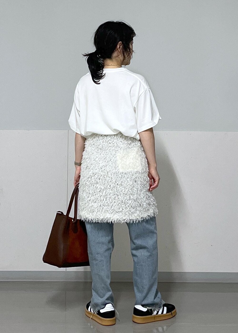 ホワイト系のTシャツ/カットソー、ホワイト系のスカート、ブラウン系のハンドバッグを着用したレディースの夏コーディネートの3枚目の写真