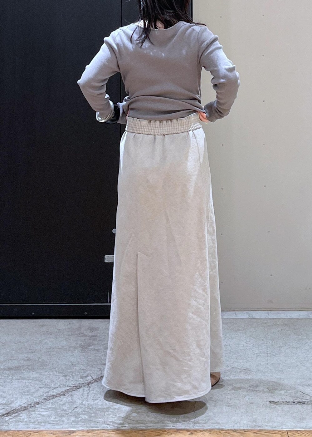 ブラック系のボストンバッグ、ベージュ系のパンプス、ベージュ系のスカートを着用したレディースの冬コーディネートの10枚目の写真