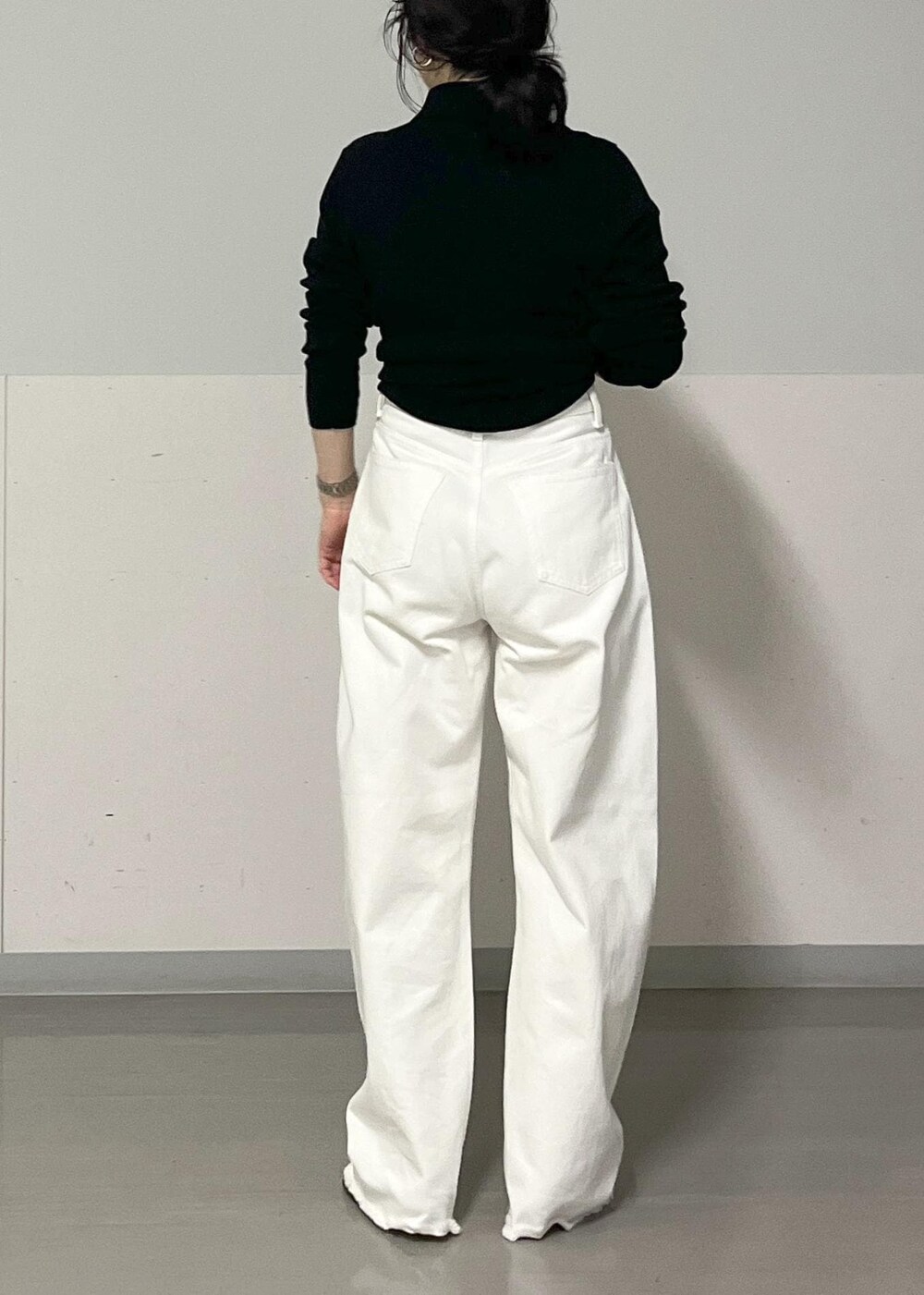 シルバー系のサンダル、ホワイト系のデニムパンツ、ブラック系のハンドバッグを着用したレディースの夏コーディネートの5枚目の写真