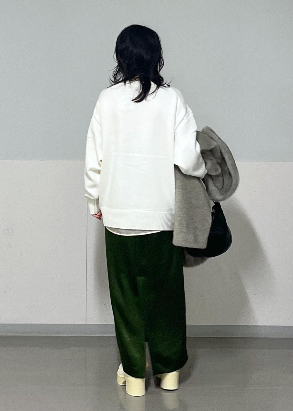 グリーン系のスカート、ホワイト系のシャツ/ブラウス、グレー系のブルゾンを着用したレディースの冬コーディネートの3枚目の写真