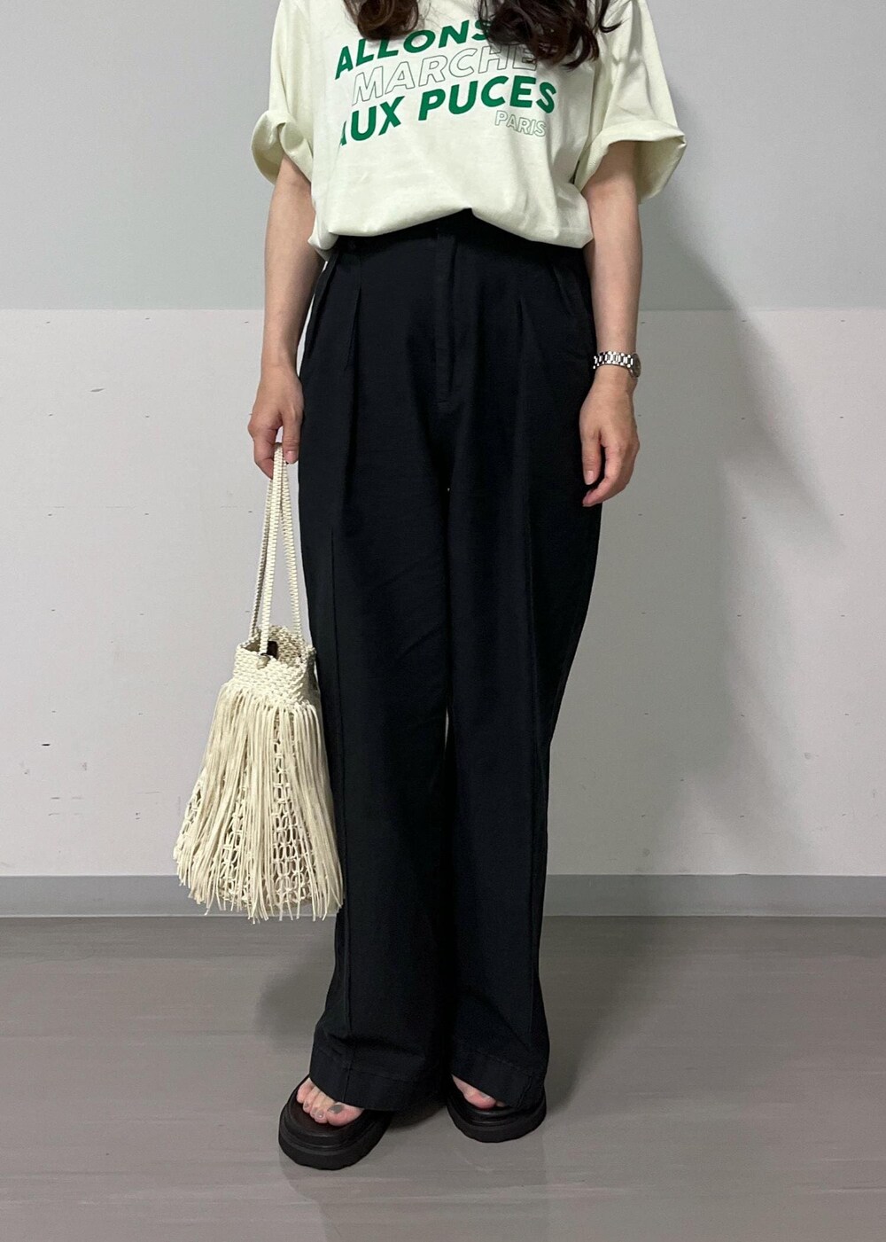 ブラック系のデニムパンツ、グリーン系のTシャツ/カットソー、ブラック系のサンダルを着用したレディースの夏コーディネートの7枚目の写真