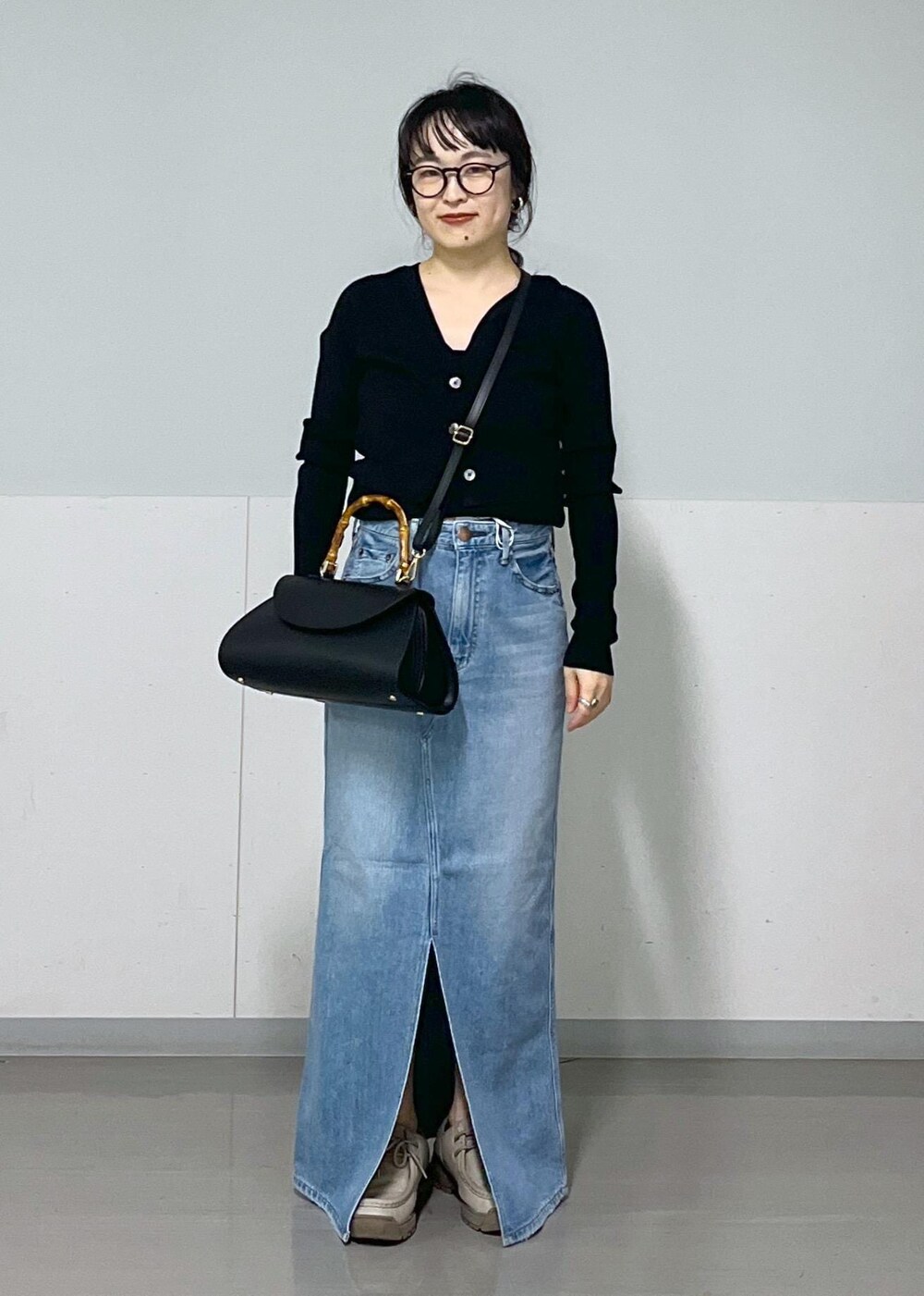 ブラック系のキャミソール、ブラック系のカーディガン/ボレロ、グリーン系のシャツ/ブラウスを着用したレディースの春コーディネートの5枚目の写真