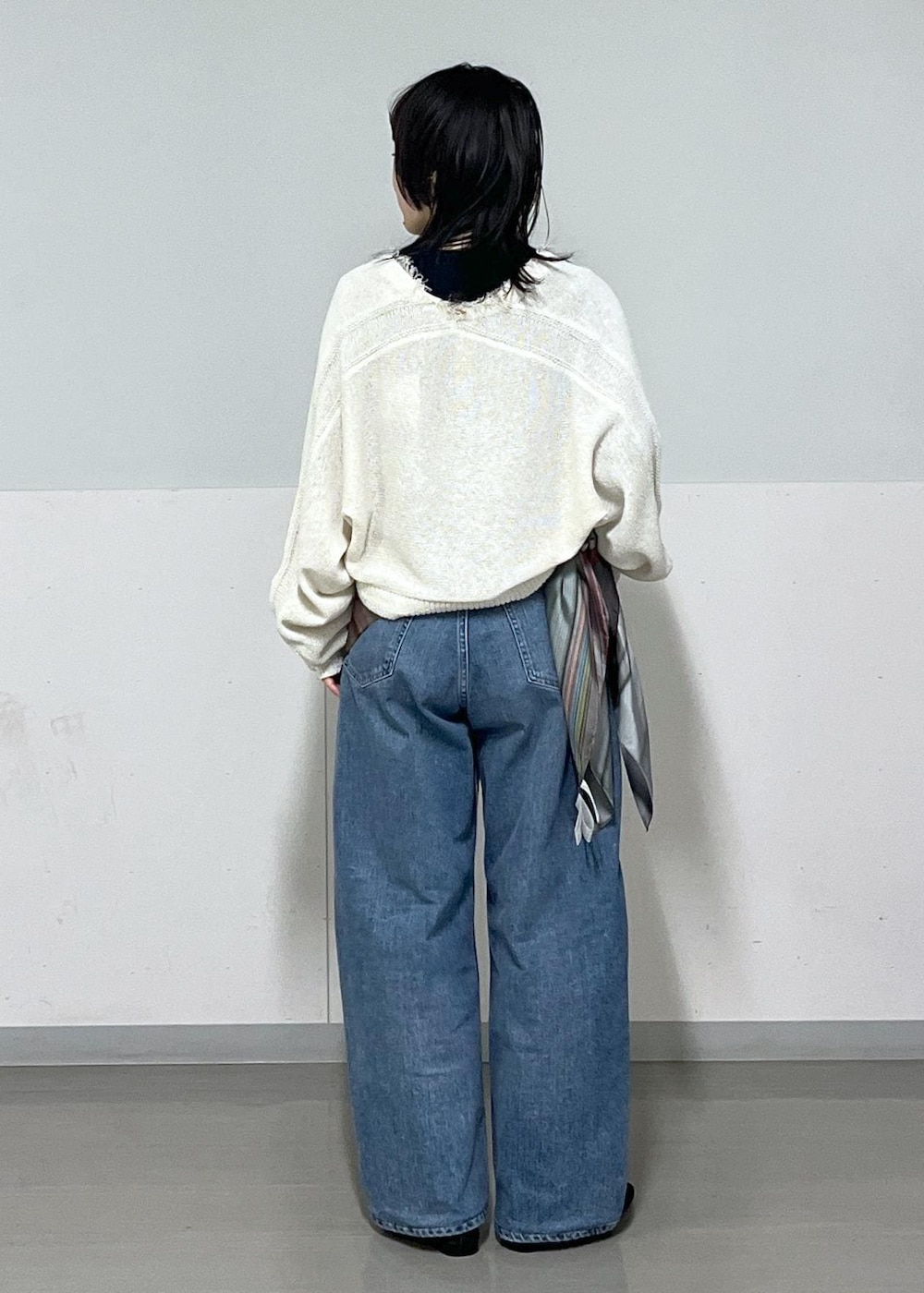 ブラック系のパンプス、ブルー系のデニムパンツ、ホワイト系のカーディガン/ボレロを着用したレディースの冬コーディネートの3枚目の写真