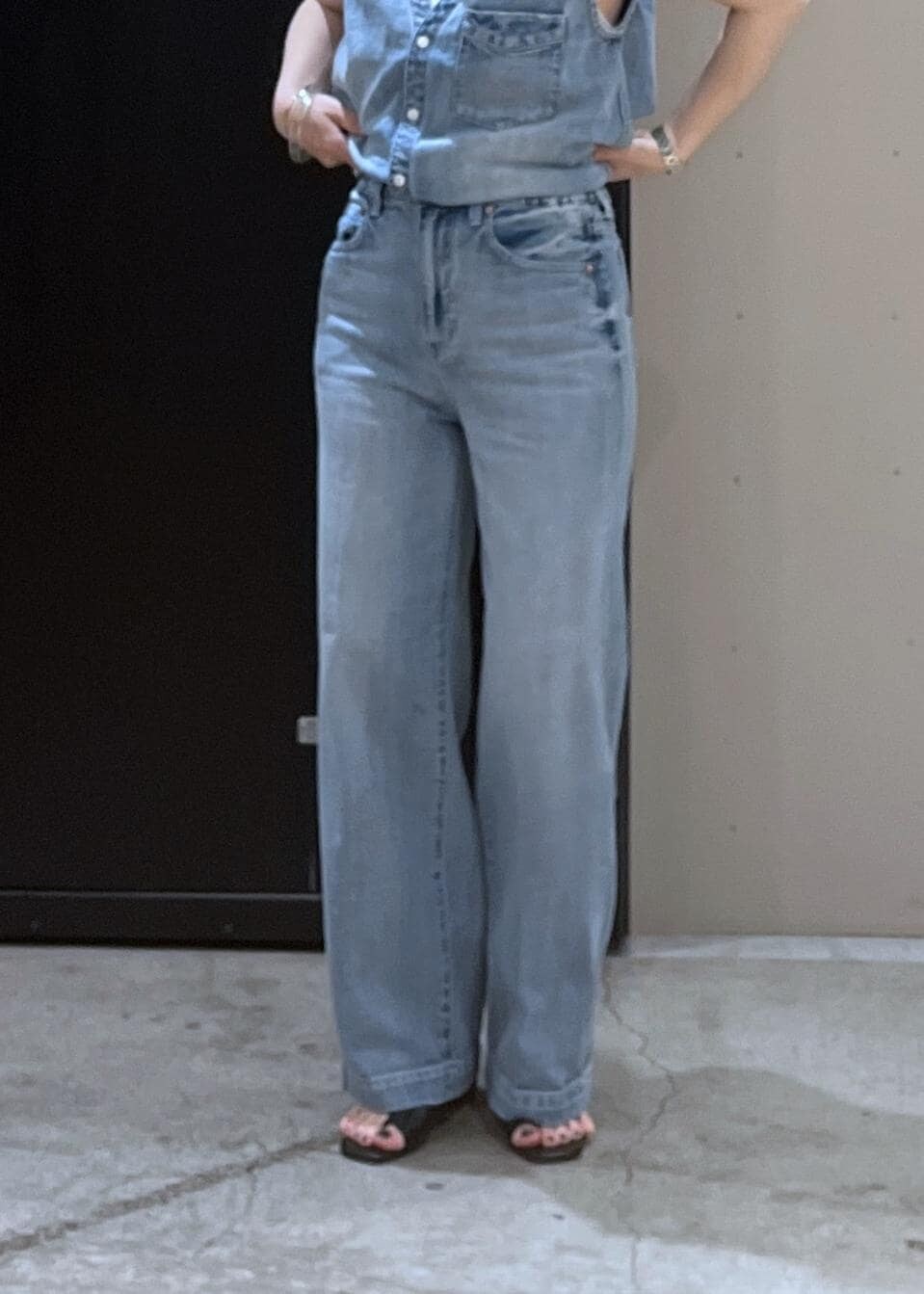 ホワイト系のキャミソール、ブラック系のサンダル、ブルー系のベストを着用したレディースの春コーディネートの4枚目の写真