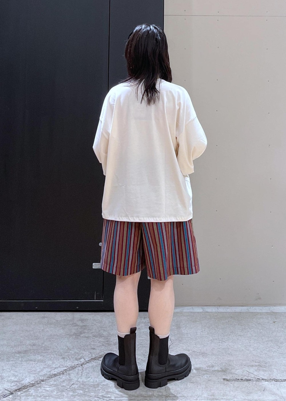 ブラック系のボストンバッグ、ブラック系のブーツ、ホワイト系のTシャツ/カットソーを着用したレディースの冬コーディネートの6枚目の写真
