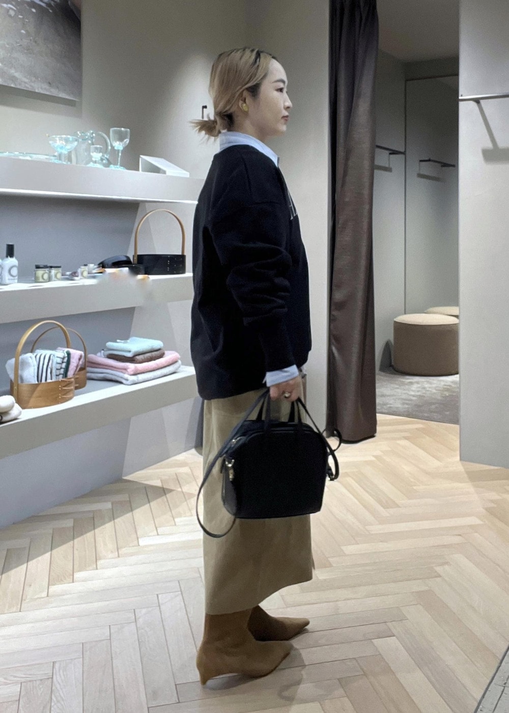 ベージュ系のスカート、ブラック系のショルダーバッグ、イエロー系のブーツを着用したレディースの冬コーディネートの2枚目の写真